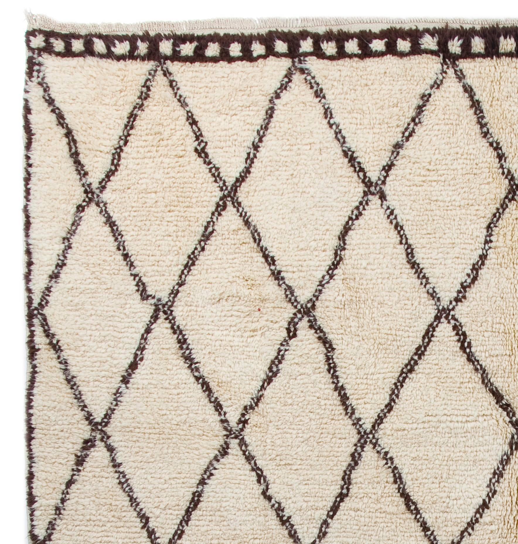 A contemporary hand-knotted Moroccan rug, made of un-dyed sheep's wool in ivory and brown. 
It has soft, lustrous wool pile that is ideal for families with kids and those who seek coziness and comfort with a modern, minimalist aesthetic. The rug