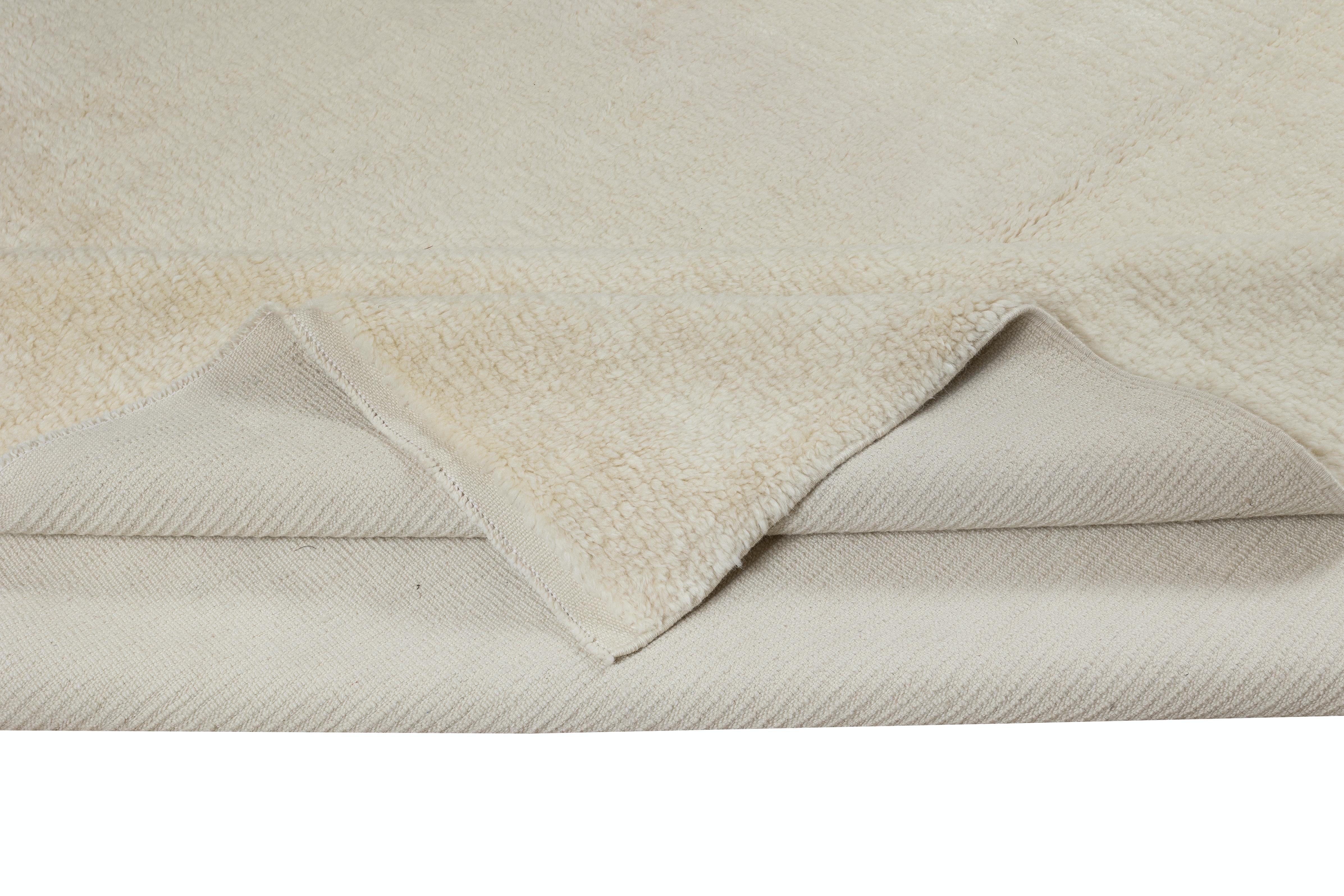 Erhöhen Sie Ihren Wohnraum mit der schlichten Eleganz dieses neuen handgeknüpften, minimalistischen, einfarbig beigen türkischen Tulu-Teppichs, der fachmännisch aus luxuriöser Wolle gefertigt wurde. Dieser Teppich verkörpert die Essenz des modernen