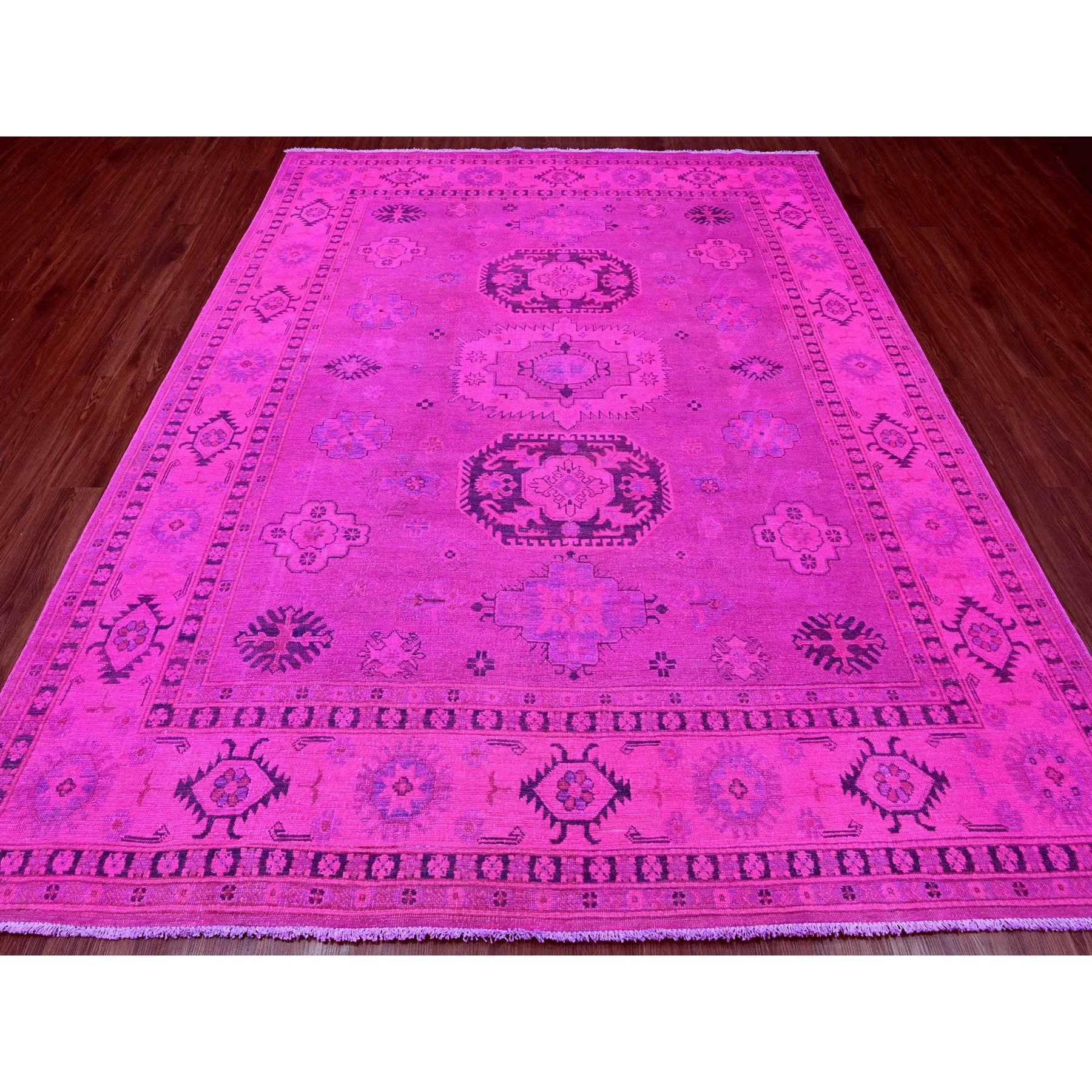 Il s'agit d'un véritable tapis d'Orient, unique en son genre, noué à la main, 100 % laine, rose vif, surteint Kazak avec des médaillons géométriques. Il a été noué pendant des mois et des mois selon des techniques de tissage séculaires par des