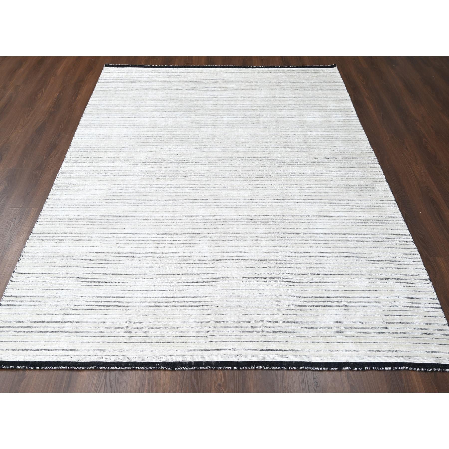 Wool and Plant Based Silk, Modern Textured and Variegated Line Design, Hand Loomed, Oriental Rug.
Primary materials: Wool and Plant based Silk
Latex: No Pile 
height: 0.25 Inches
Style: Casual
Primary color: Ivory
Secondary colors: Black
Pattern: