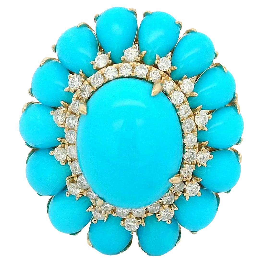 Questo straordinario anello in oro giallo 14k è una celebrazione di colori vivaci e di eleganza senza tempo. Il centro è caratterizzato da un audace cabochon di turchese di 8x10 mm, circondato da una serie di altre pietre di turchese di 4X6 mm. Le