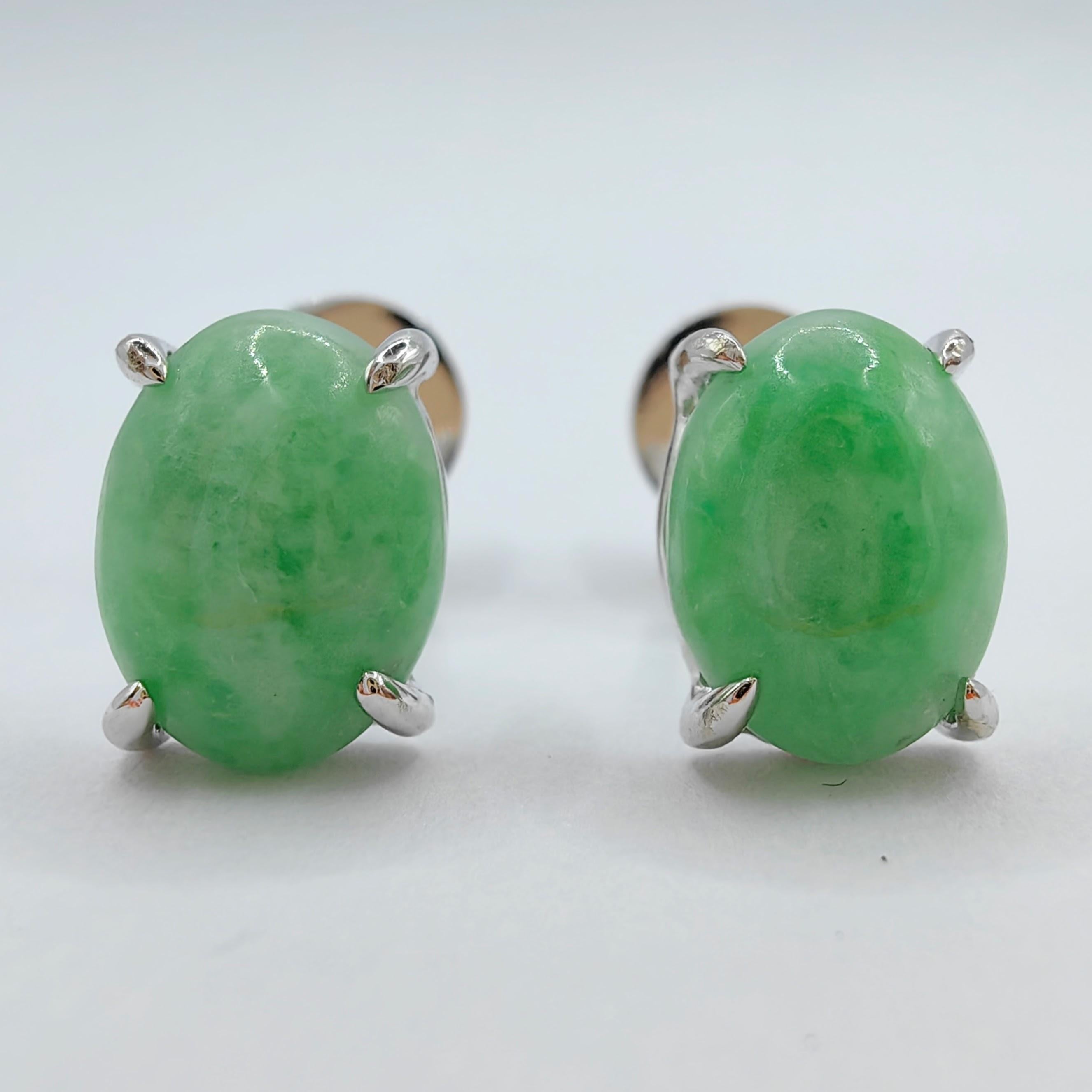 Introducing our stunning 8x6mm Burmese Oval Cabochon Apple Green Jadeite Jade Ear Studs in 18K White Gold, a pair of exquisite earrings that exude elegance and showcase the natural beauty of jadeite jade. These ear studs feature two captivating