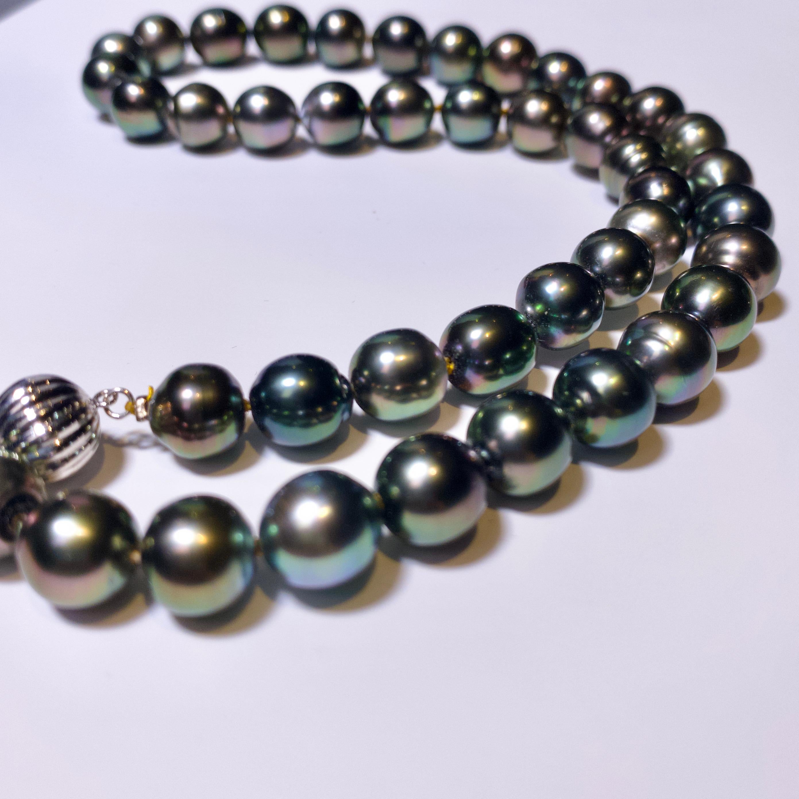 A Strand of Black Colour Green Tone Tahitian Pearl necklace with 18K Gold Clasp. The Pearls are showing plays of colour and it will be particularly obvious under natural light. This colour is called peacock green in trade and the colour of the