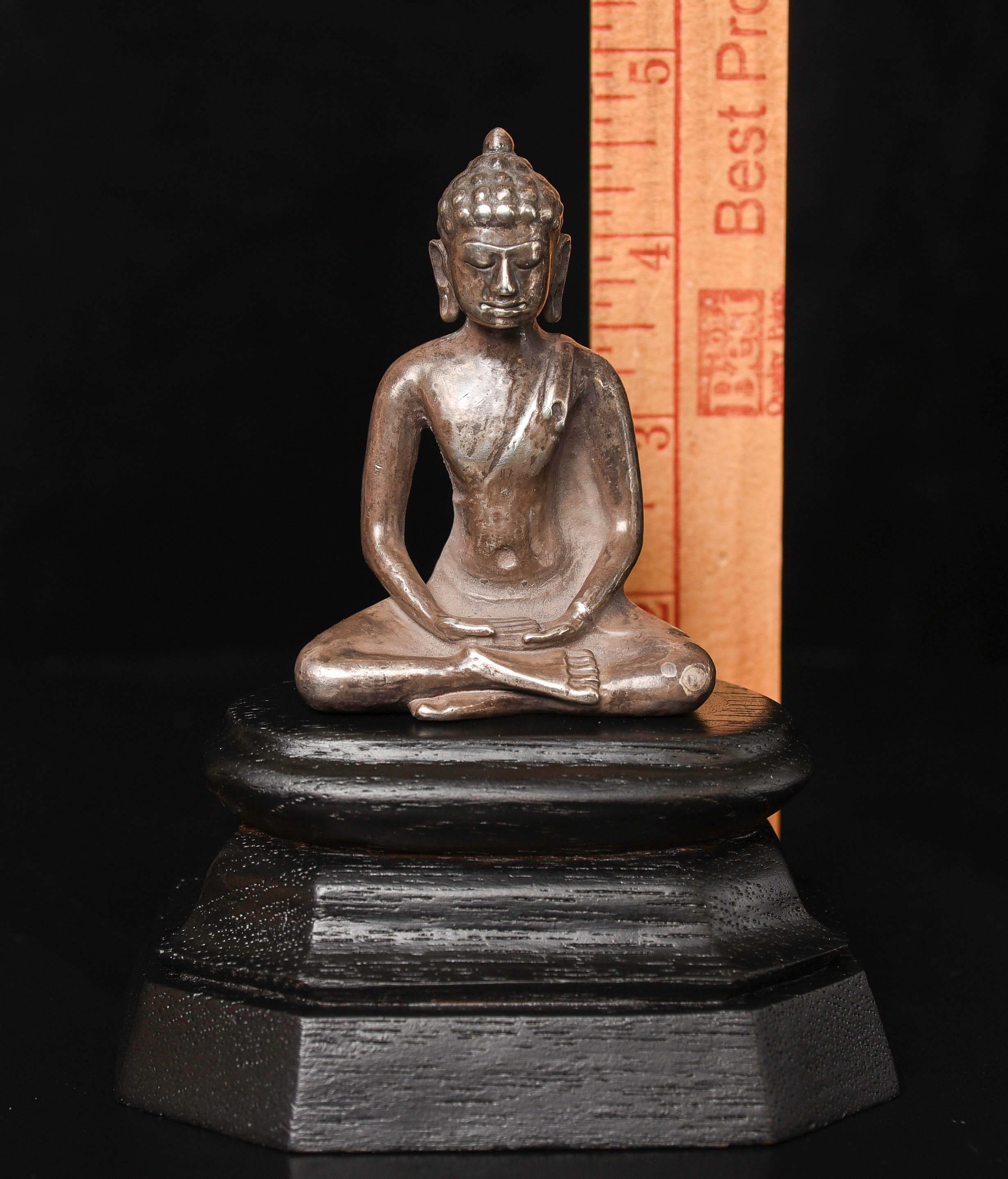 This is a (possibly solid) silver Dvarati Buddha, probably from Thailand, certainly from SE Asia. Dated to the 9-11thC. I have not measured the purity of the silver, and have no way to know for sure if it is solid cast, except for the weight, which