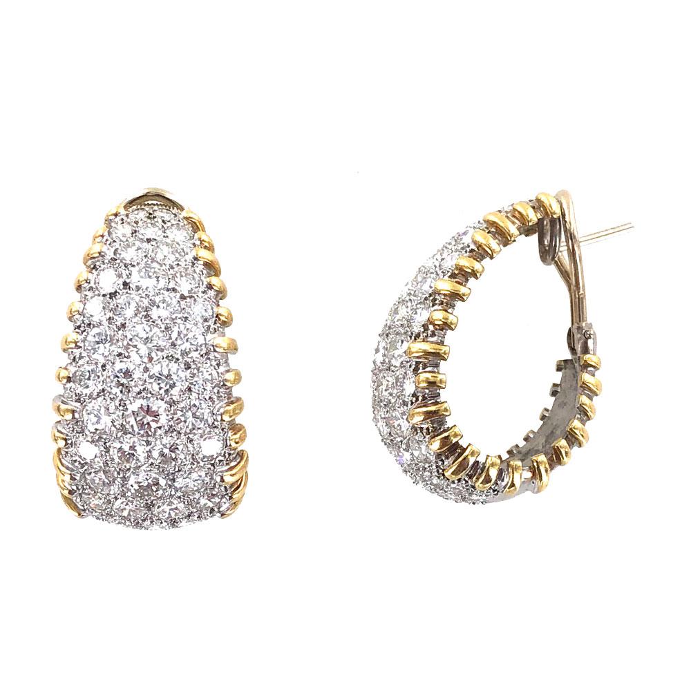 These sparkling diamond half hoop earrings are fashioned in 18 karat yellow and white gold. The earrings feature 9.0 carat total weight of round brilliant cut diamonds graded G-I color and VS-SI1 clarity. The tapered hoops measure 18mm in width