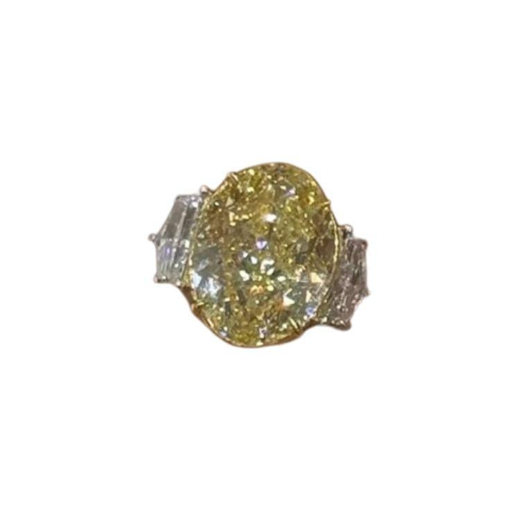Diamant central :
Poids en carats : 8,52 carats
Couleur : FANCY LIGHT YELLOW -FLY
Style : OVAL BRILLIANT

Trois pierres de diamant :
Poids en carats : 0,87 carats
Couleur : Whiting
Style : Demi-lune
 
Anneau :
Cadre : Trois pierres
Taille : Peut