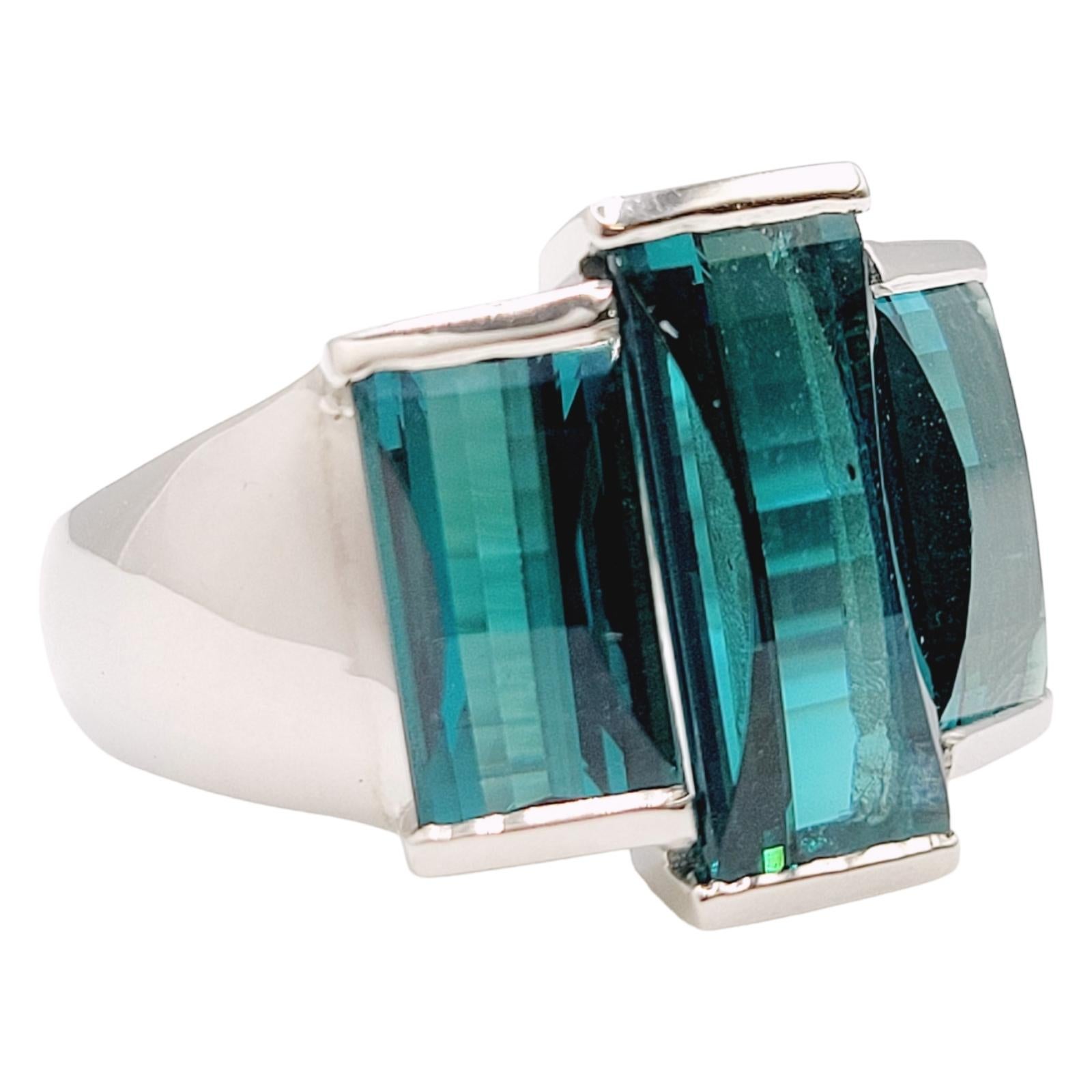 Ring size: 10.5

Introducing a breathtaking 9-carat rectangular step-cut three-stone tourmaline cocktail ring in platinum, a true masterpiece that effortlessly combines elegance and sophistication. Crafted with the utmost attention to detail, this