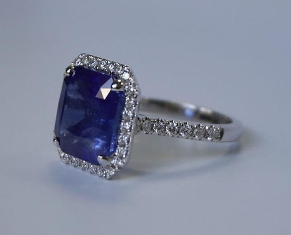 Sapphire Weight: 9.15 ct, Measurements: 12 x 11.5 mm, Diamond Weight: 0.57 ct (42 pcs), Metal: 18K White Gold, Gold Weight: 5.17 gm, Ring Size: 6.5, Shape: Emerald-Cut, Color: Blue, Hardness: 9, Birthstone: September