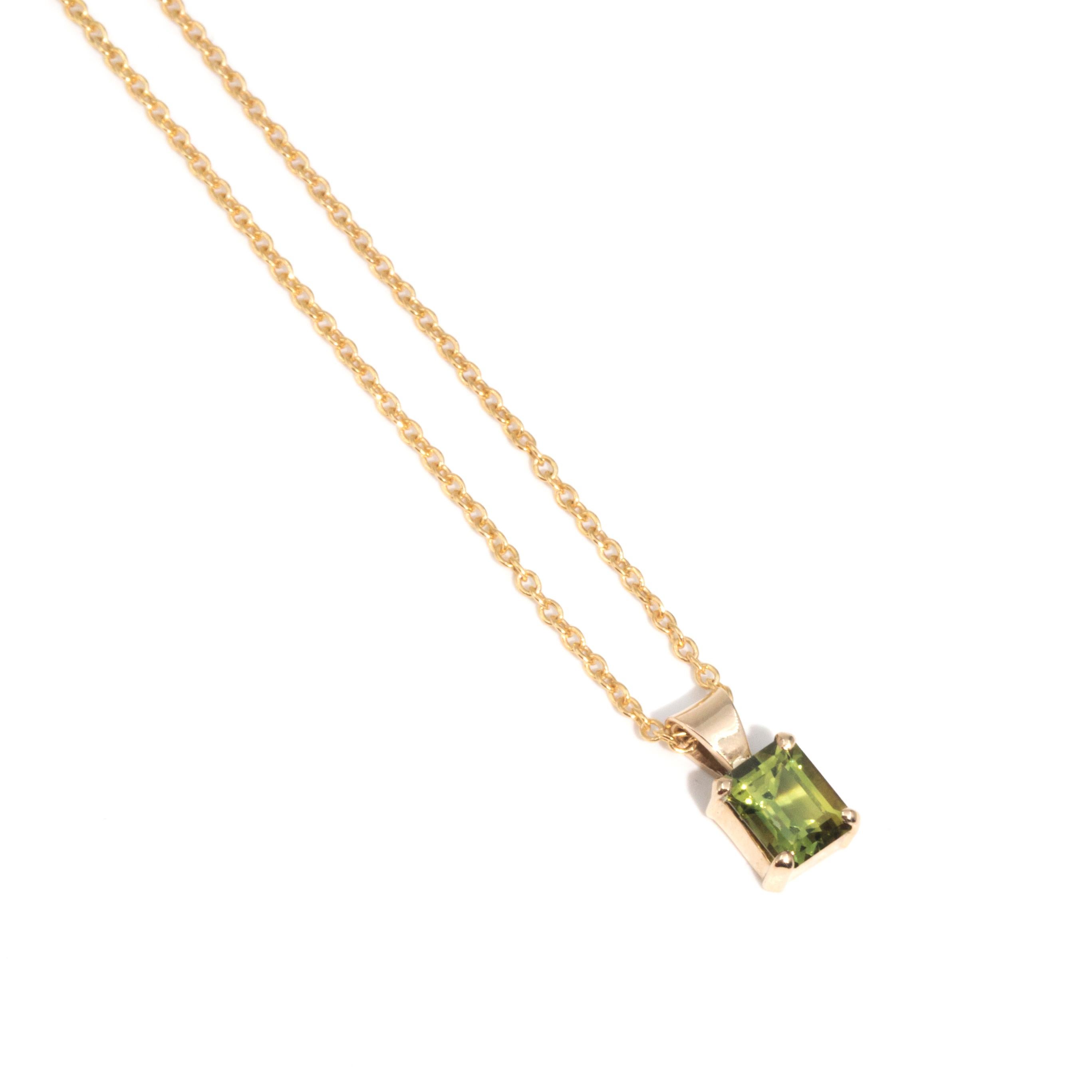 Crafted in 9 carat yellow gold, this charming vintage pendant features an alluring bright green emerald cut sapphire resting in an elegant four claw setting. The pendant is threaded on a fine 9 carat yellow gold cable chain. We have named this jewel