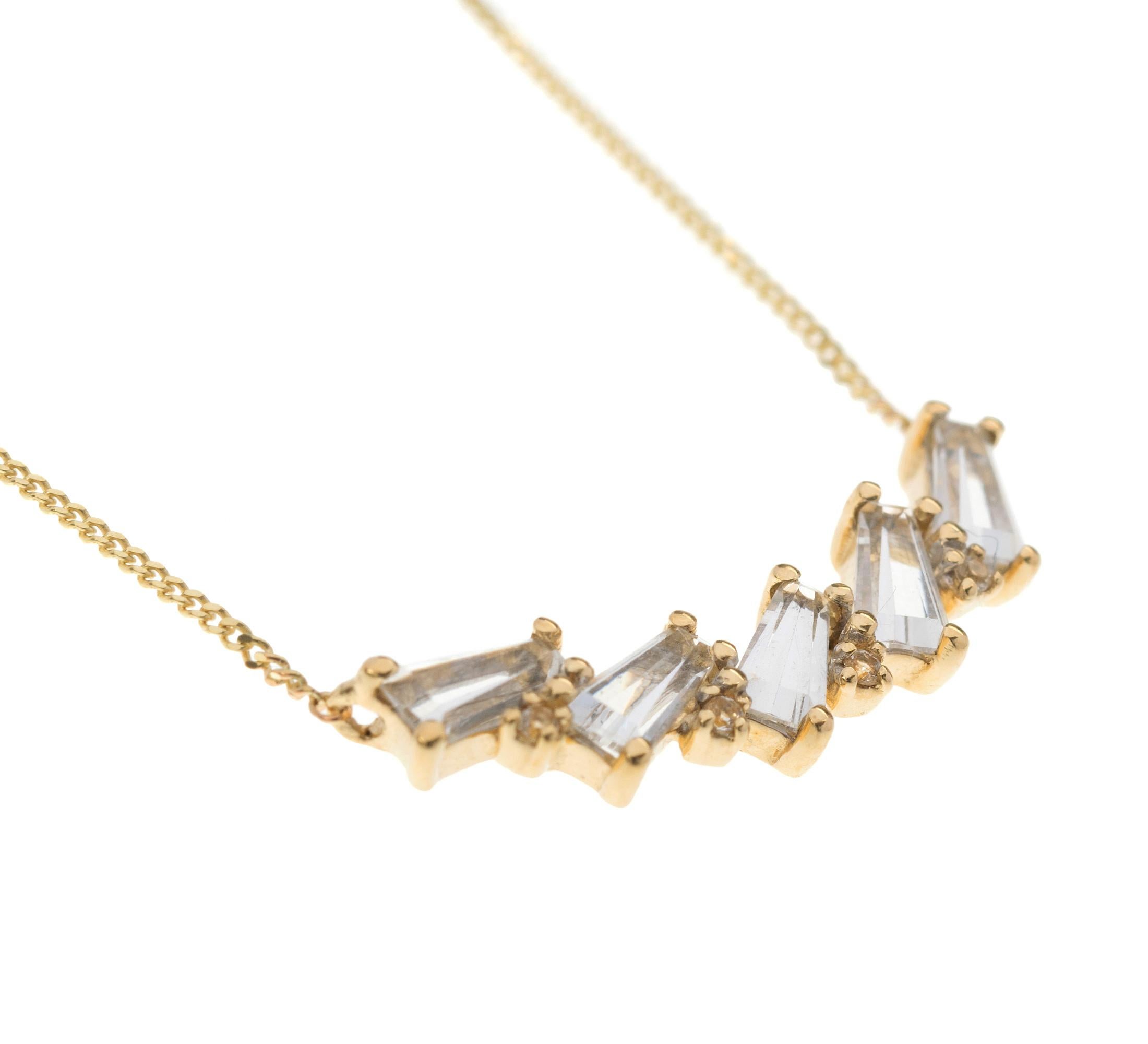 A scintilating geometric designed necklace set with round and tapered baguette cut shimmering colourless Topaz all framed in 9ct yellow gold. The adjustable chain allows choice in length and style. A versatile and popular choice for desk til dusk