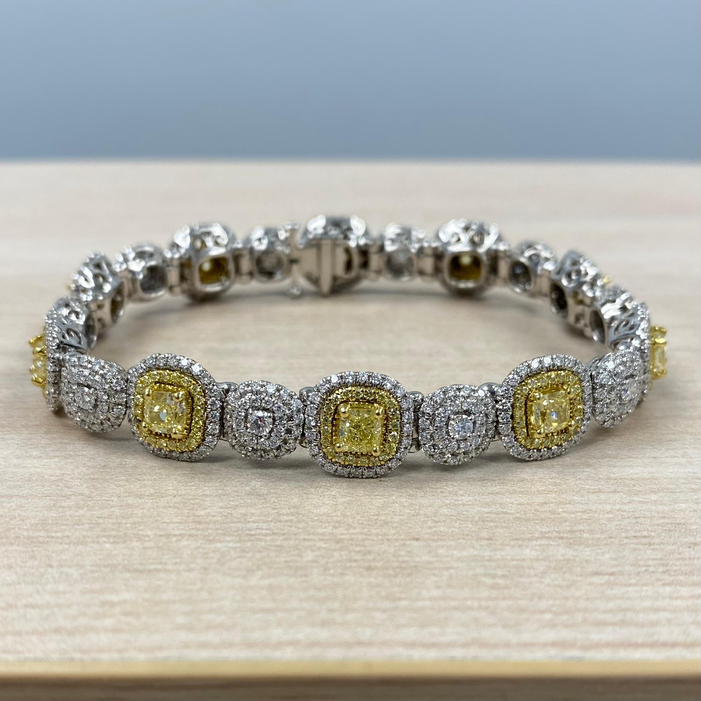 This gorgeous bracelet showcases 4.13 carats of exquisite fancy yellow cushion-cut diamonds, each encircled by a double halo of radiant yellow and white round-cut diamonds. The diamonds are linked by clusters of sparkling colorless round-cut