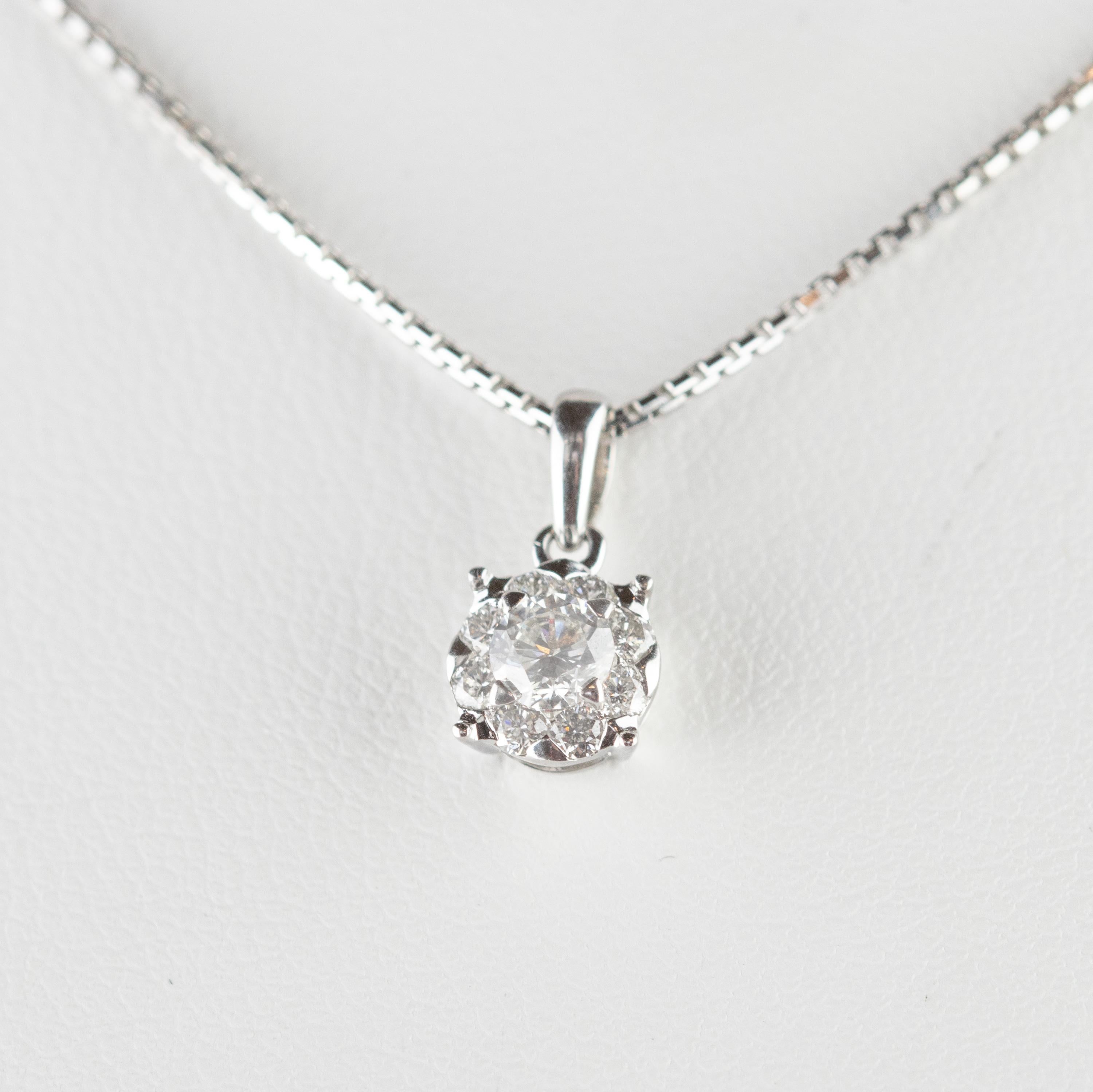 Un magnifique diamant solitaire italien rond de 0,25 carat entouré de huit diamants de 0,18 carat pour un total de 0,43 carat, serti dans une pièce en or blanc 18 carats et retenu par une chaîne en or blanc de 42,5 cm. Le bijou artisanal parfait