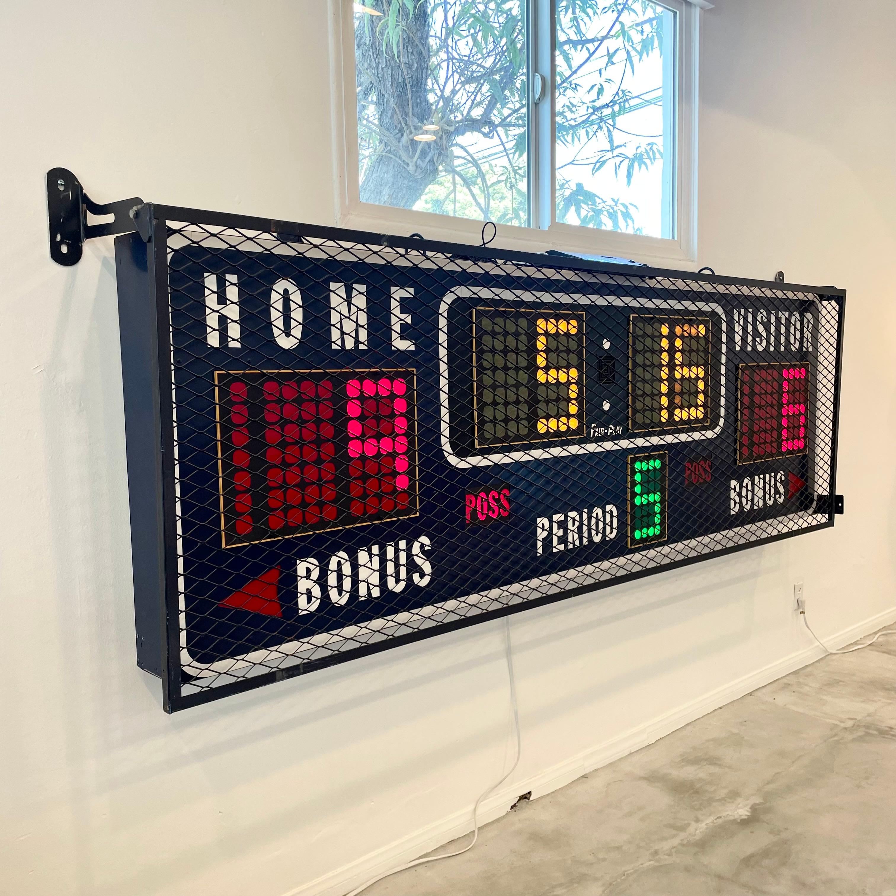 Vintage basketball scoreboard by Fair Play, made in the 1980s. Unusual size with an industrial metal cage that protects the face of the board and can be lifted up in order to work on the board. Navy blue colored board. Board and metal case in very