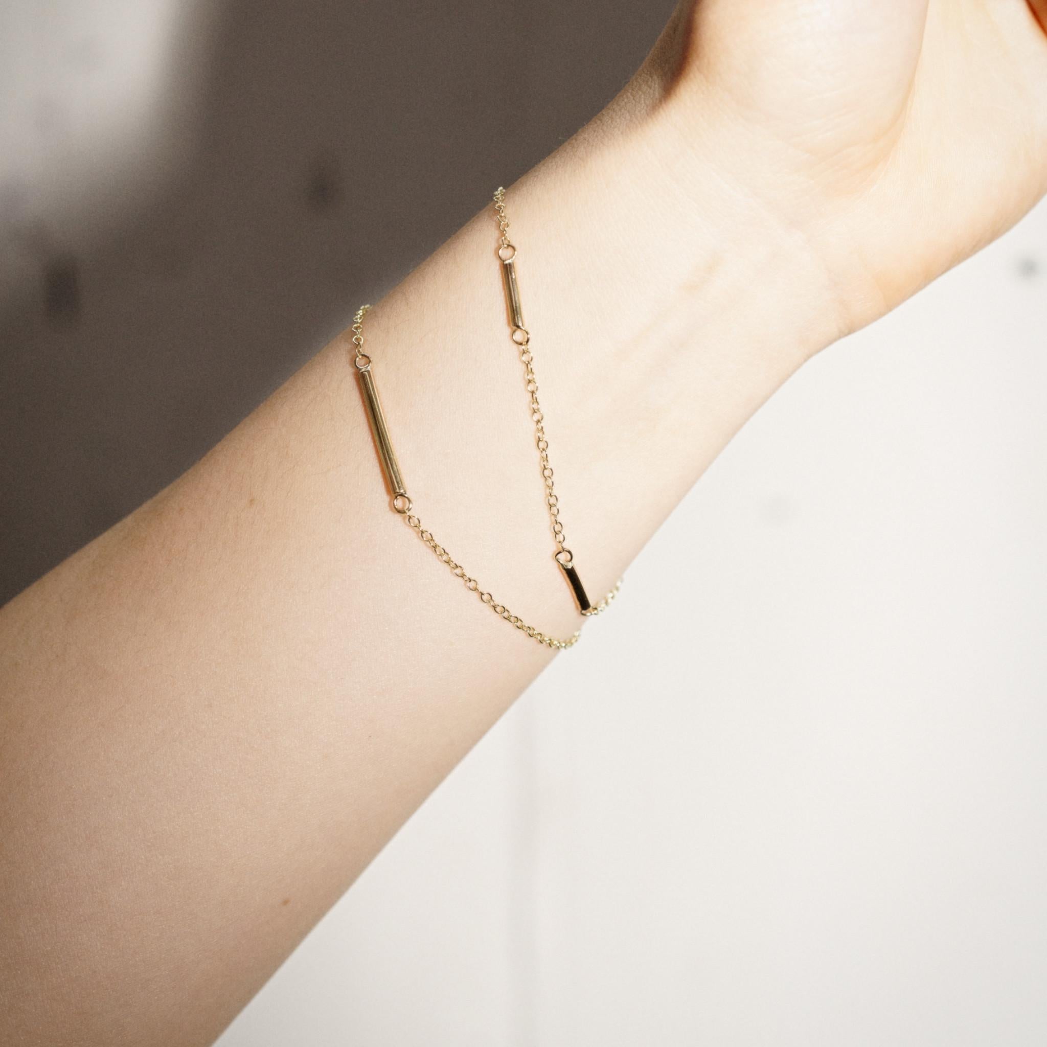 Esta elegante pulsera está hecha a mano con una delicada cadena de eslabones y tres lingotes individuales de oro de 9 quilates. El diseño sencillo y clásico de la pulsera petite bar de oro de 9 quilates la hace perfecta para llevar a diario.

Hechas