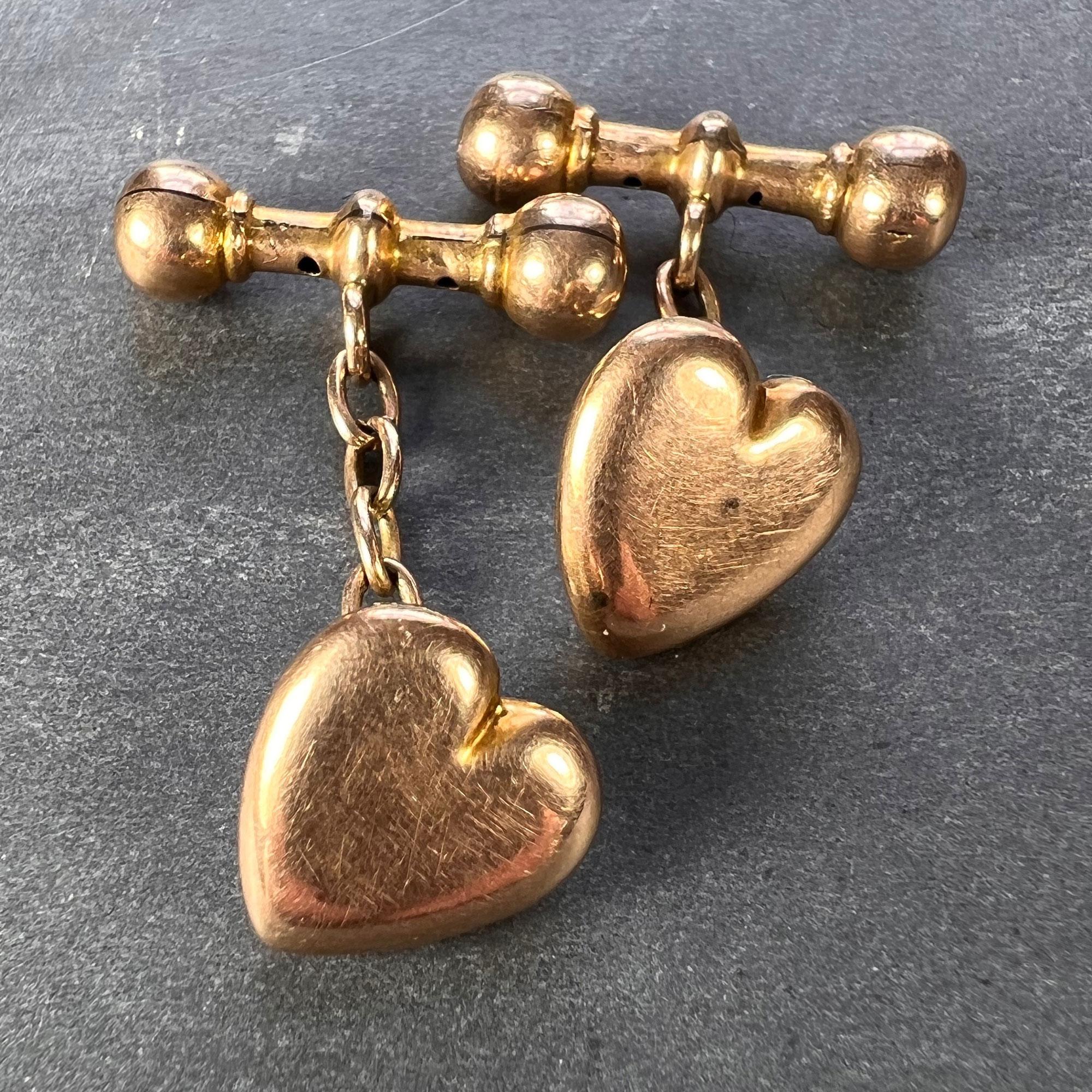 A pair of 9 karat (9K) rose gold cufflinks designed as a puffy heart to the front with a ridged bar to the reverse. Hallmarked for 9 karat gold, Birmingham, 1912 with makers mark for G.E. Walton & Co Ltd.

Dimensions: 1.3 x 1.1 x 0.4 cm