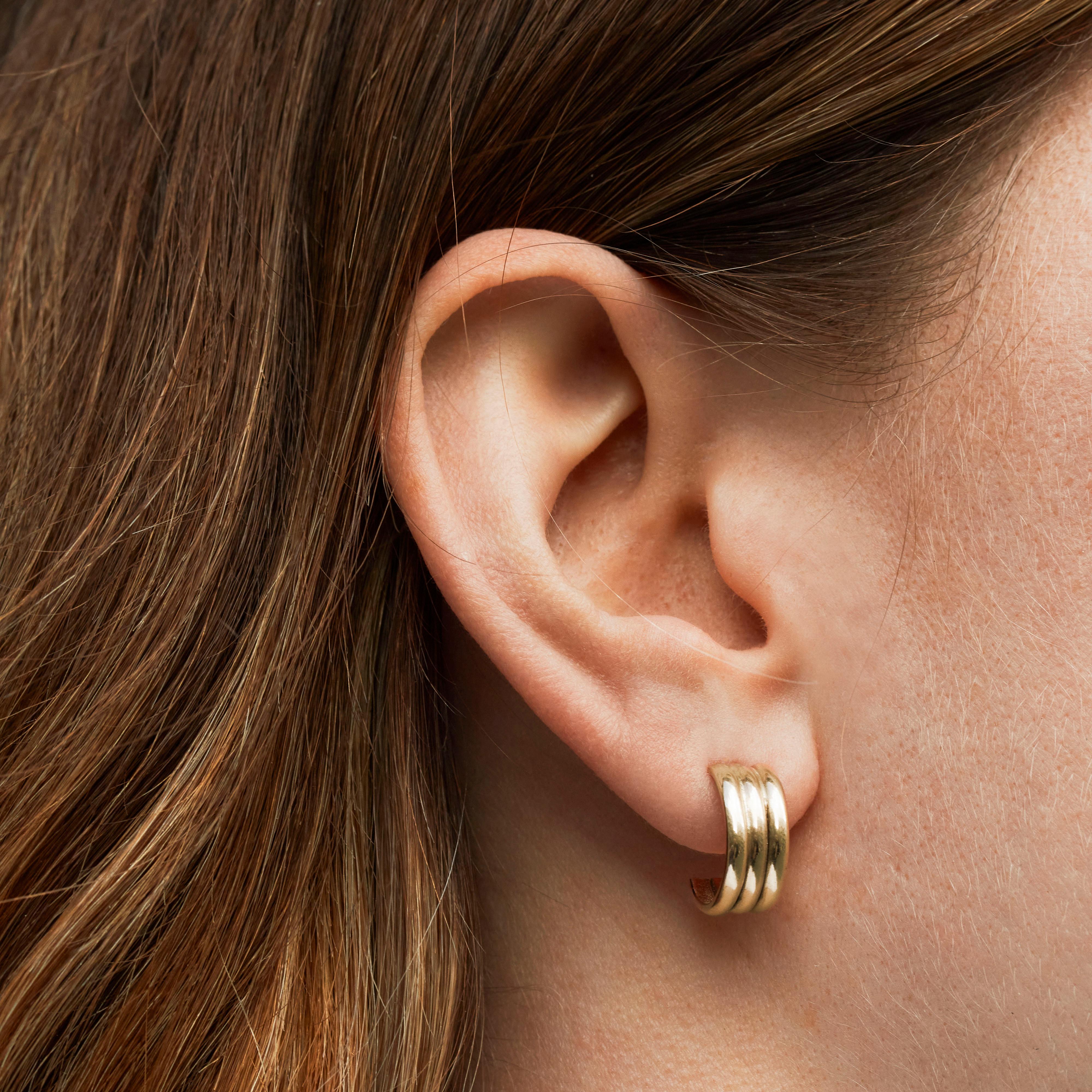 A chunkier style of hoop earring, the trio hoops are crafted to create a hoop earring with a grooved surface effect. Perfect for mixing with other hoop earrings as well as wearing on their own to elevate a casual everyday look.

The Trio Hoop
