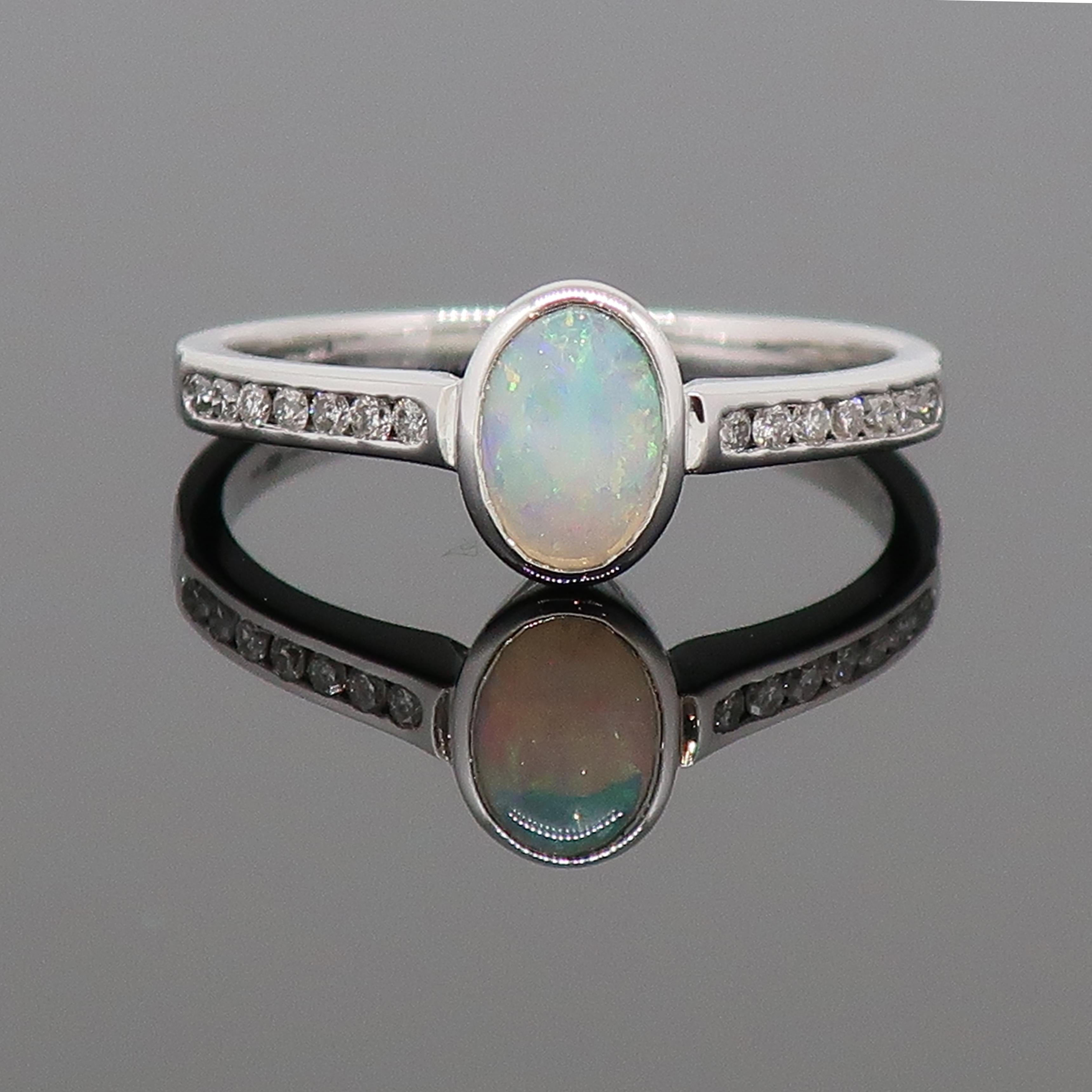 9 Karat White Gold Oval Opal Solitaire Ring With Diamond Shoulders

A dainty oval opal solitaire ring. The pretty opal is set in a delicate rub over setting, with channel set brilliant cut diamond shoulders. Each shoulder consisting of seven