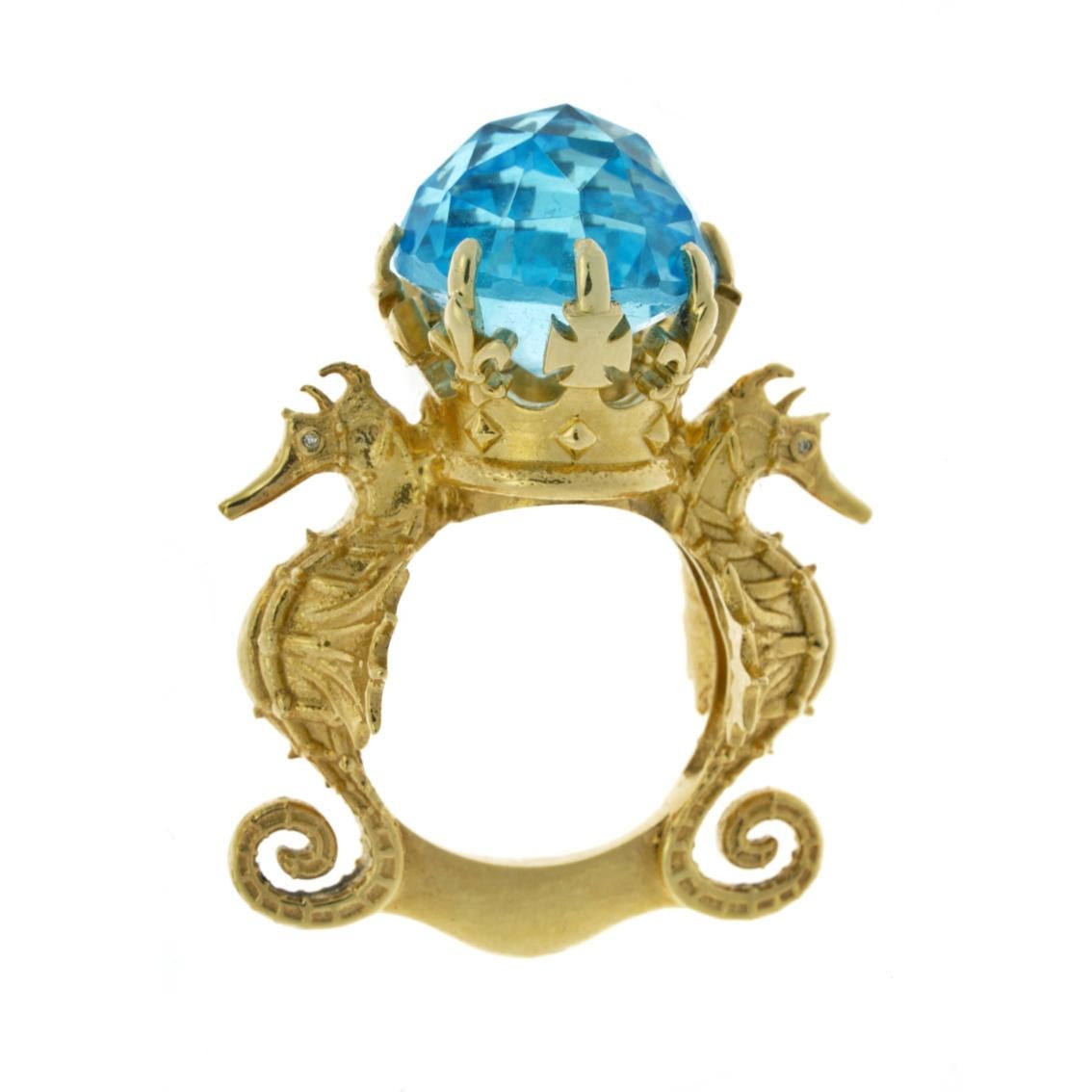 Hand crafted in 9kt yellow gold, the Amphitrite's Crown Ring features a luscious 12.6ct blue topaz perched in all it's glory atop a crown flanked by two guardian seahorses with 4 sparkling white diamond eyes.

This piece has a marvellous weight to