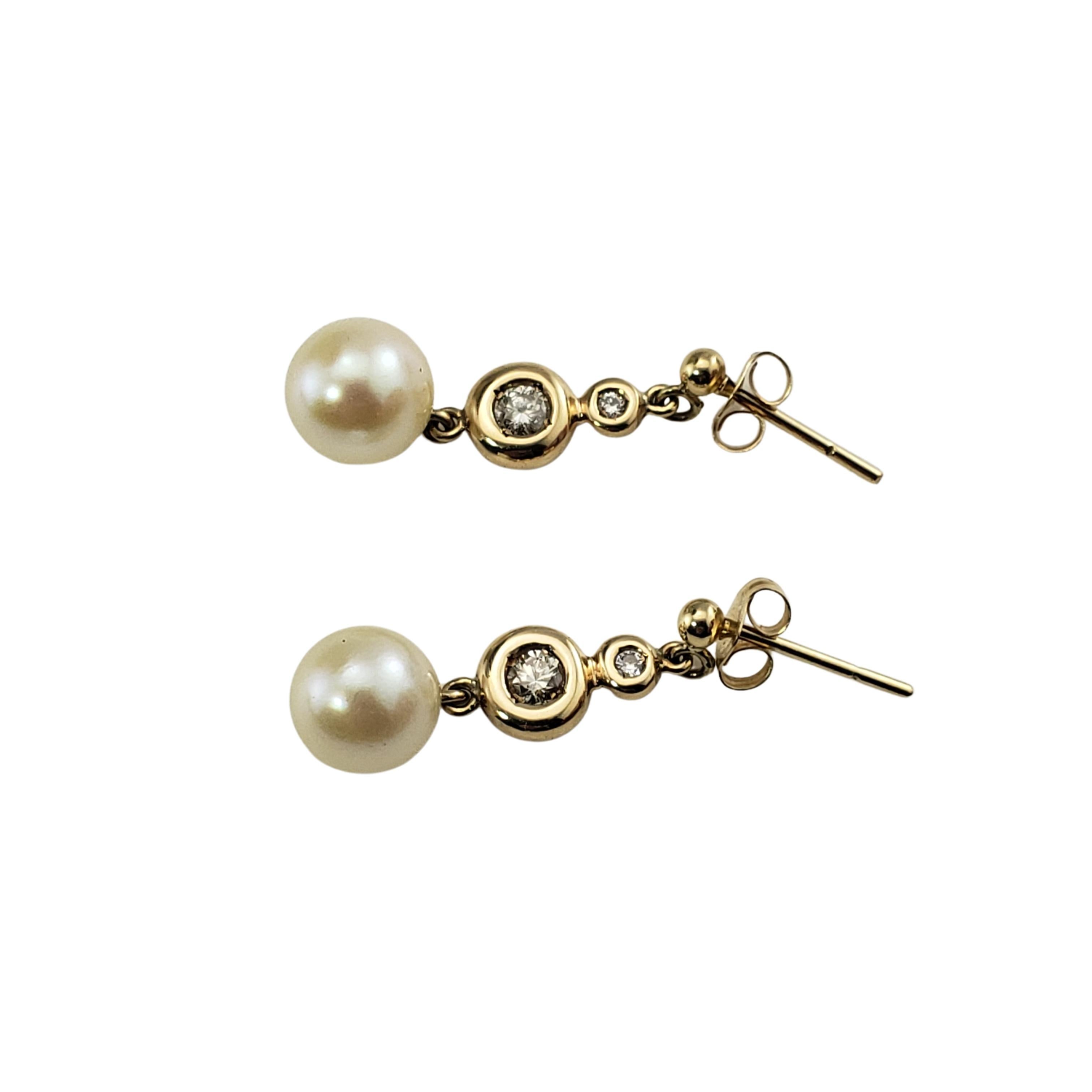 Pendants d'oreilles en or jaune 9 carats, perles et diamants -

Ces ravissantes boucles d'oreilles comportent chacune une perle ronde (8 mm) et deux diamants ronds de taille brillant sertis en or jaune 9 carats.  Fermetures à glissière au