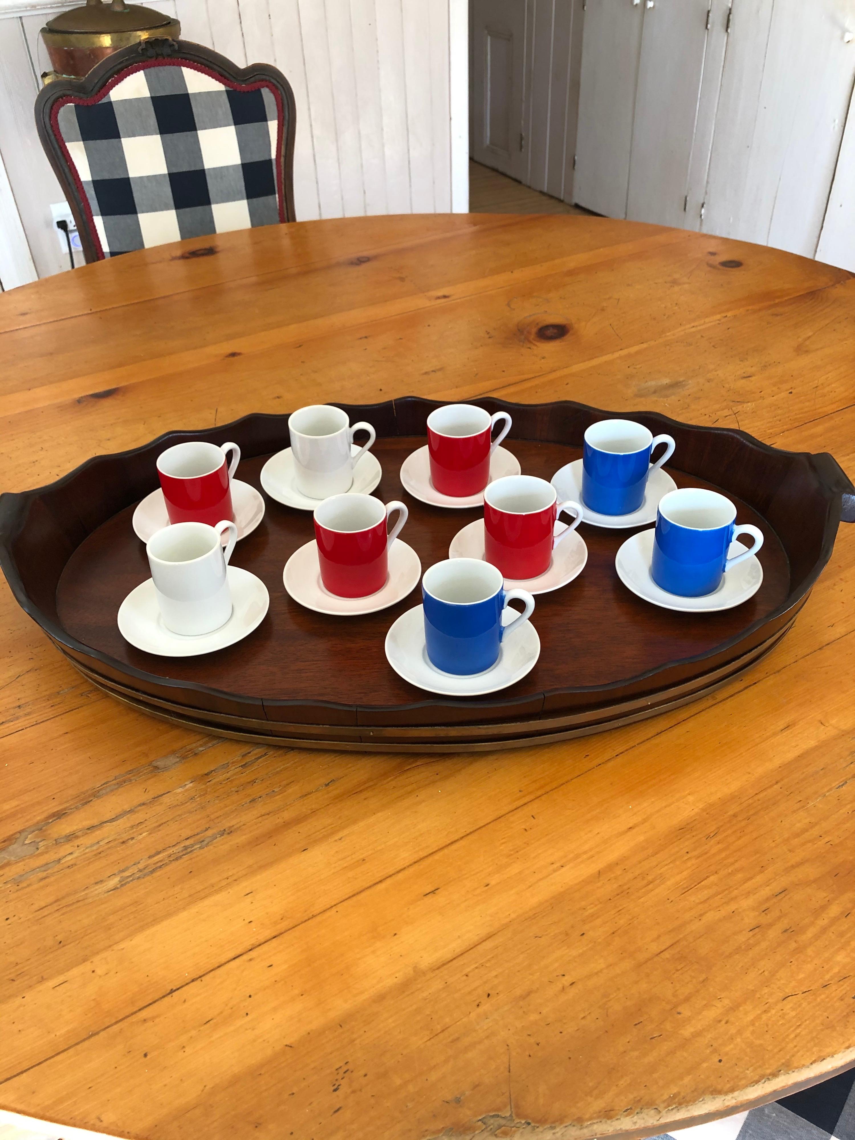 Set of 9 demitasse cups and saucers. 4 red cups, 3 blue and 2 white cups all with white saucers. Total of 18 pieces, circa 1960. Originally purchased at Azuma NYC on Lexington Avenue. Alas long gone. Measure below is for the saucers. The cups