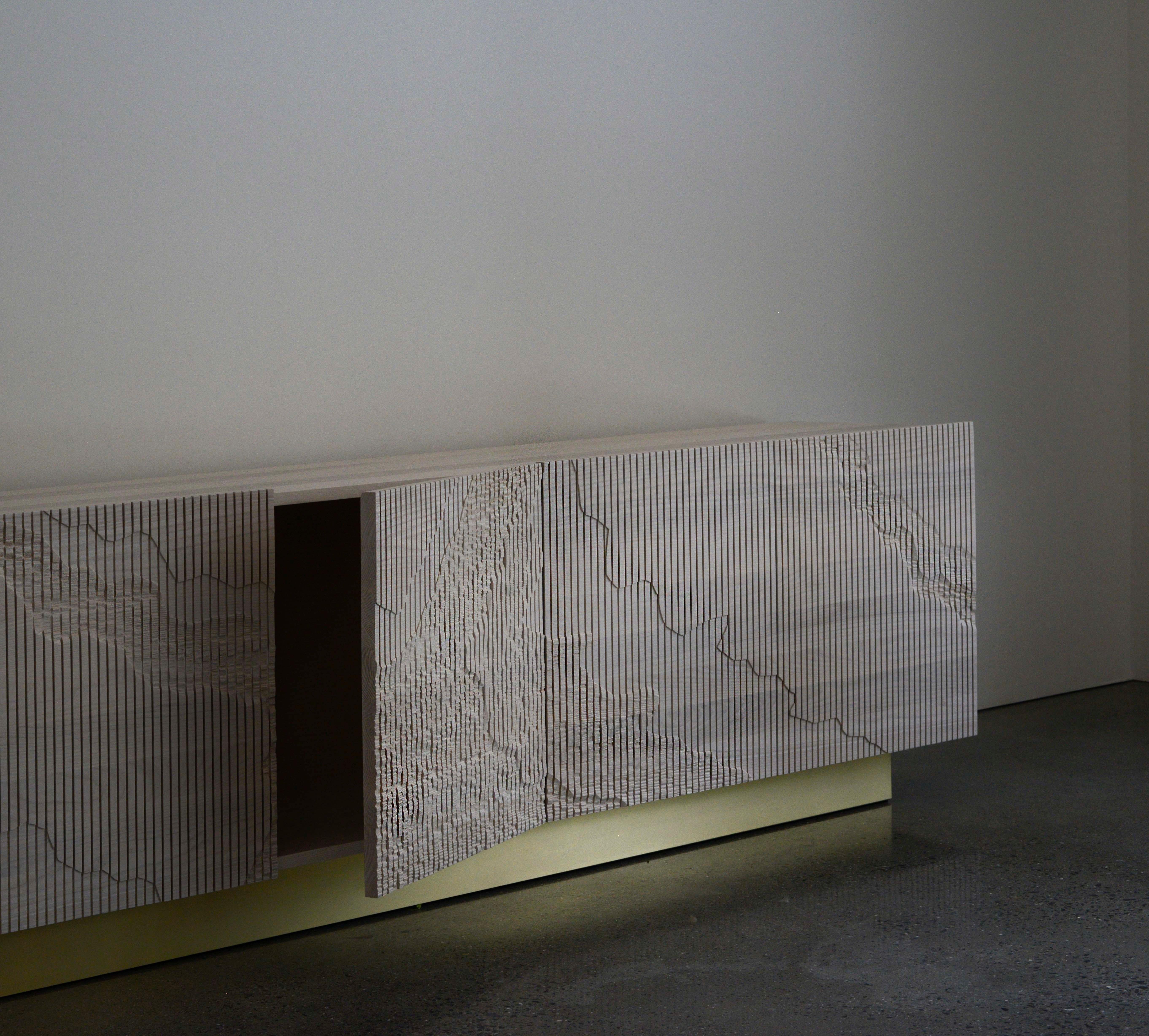Both monumental and subtle, the Shale Credenza brings the intricacies of nature’s geology indoors. The wood doors are scored vertically across the grain, and details of a cliff’s facade, mapped out by Simon Johns, are carved into them by hand