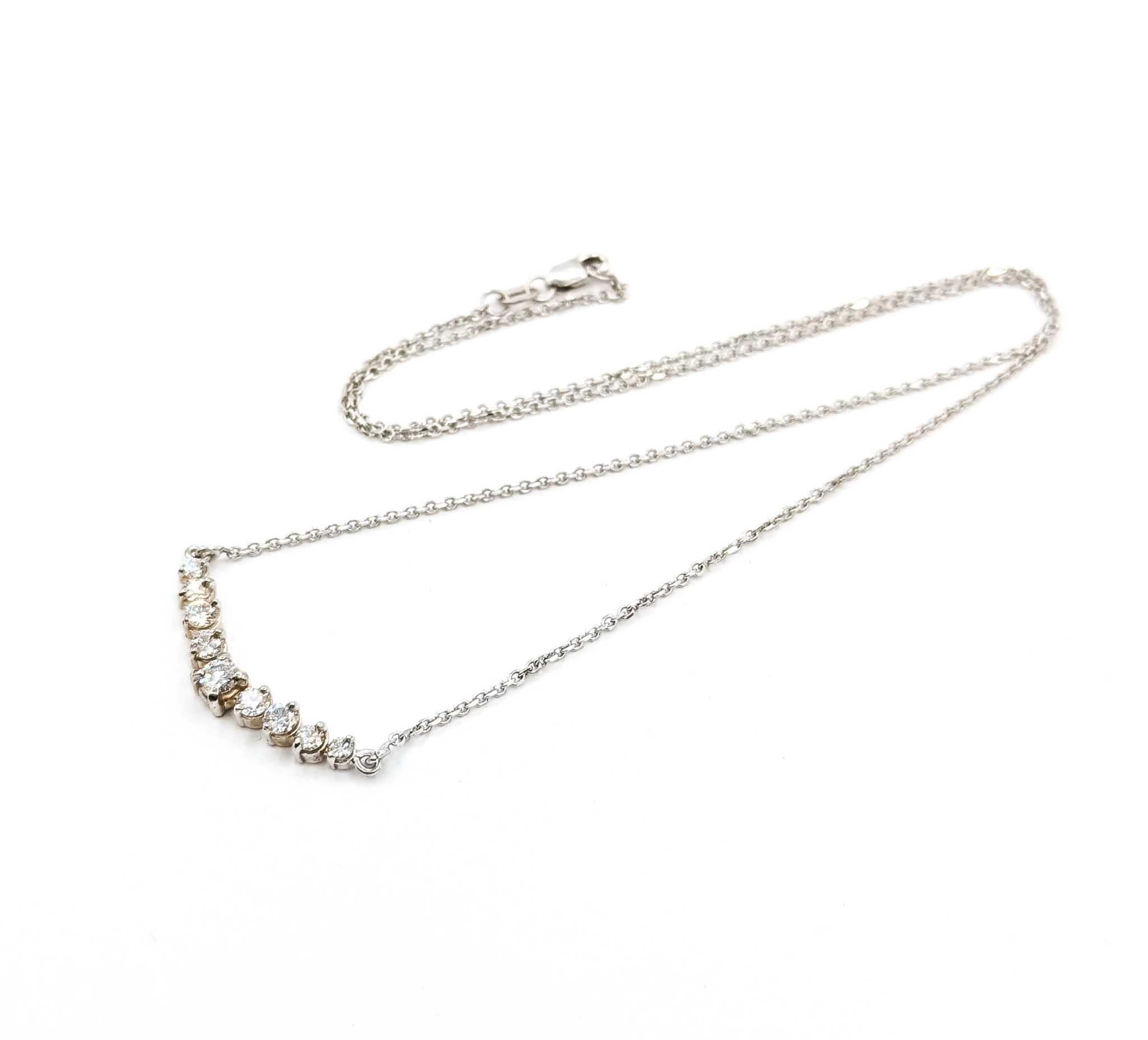 Questa raffinata collana è realizzata in oro bianco 14k e presenta una scintillante fila di nove diamanti tondi brillanti per un totale di 0,75 carati. I diamanti sono graduati e incastonati su una barra di 32 mm per 4,5 mm, creando una graziosa