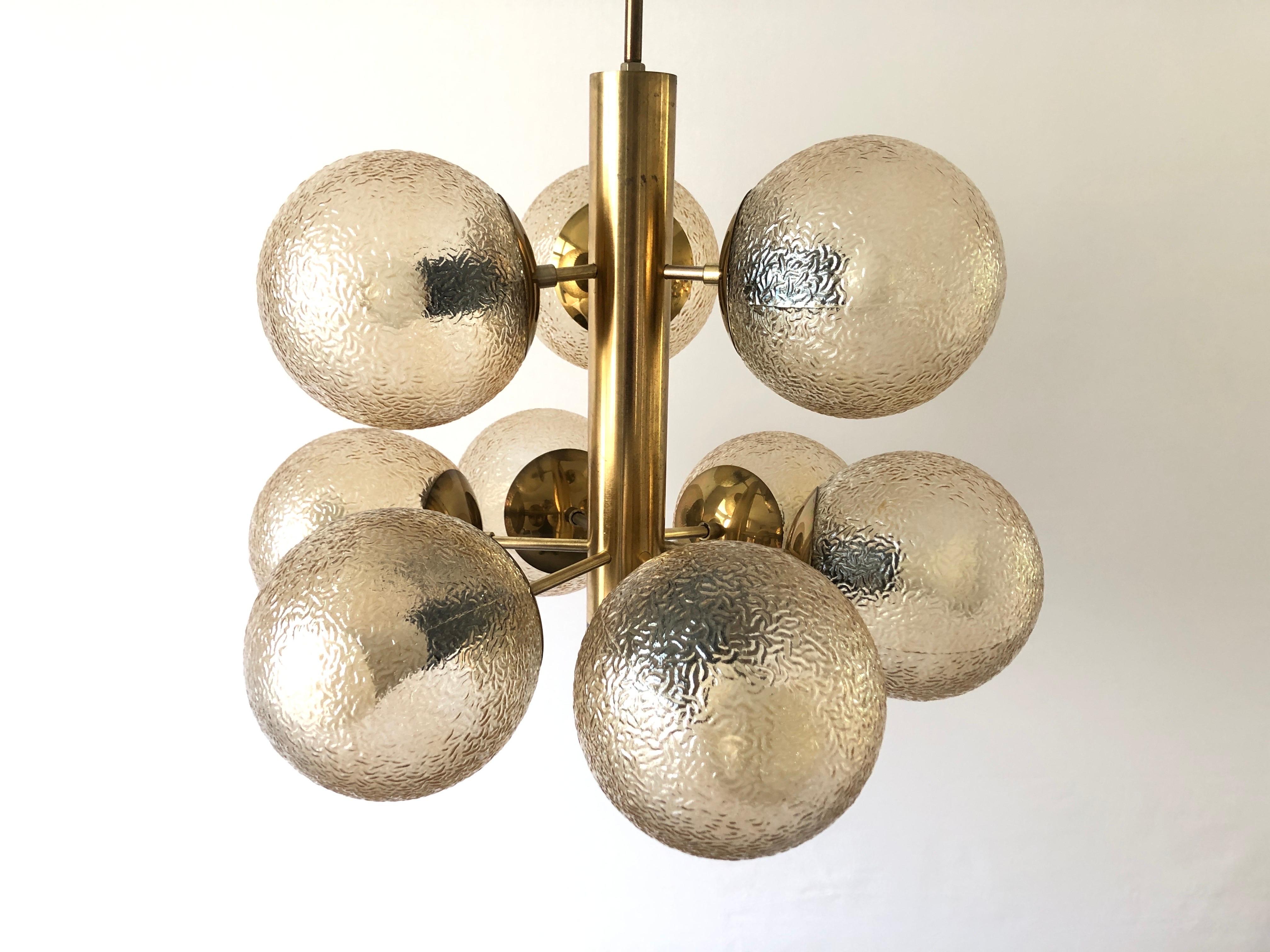9 textured smoked Glass and Brass Body Chandelier by VEB LEUCHTEN, 1970s, Germany

Lampshade is in good condition and very clean. 
This lamp works with 9 x E27 light bulb. 
Wired and suitable to use with 220V and 110V for all