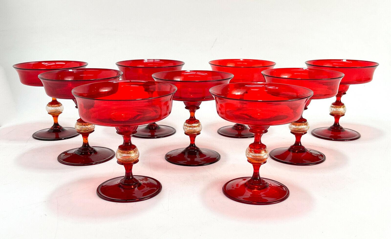 9 Venetian Murano cranberry red & gold fleck art glass champagne saucer wine goblets, attributed to Salivati. Blown stemware comprising of 4-5 pieces with a clear gold fleck bulb to the stem. Polished pontil to the underside.

Additional