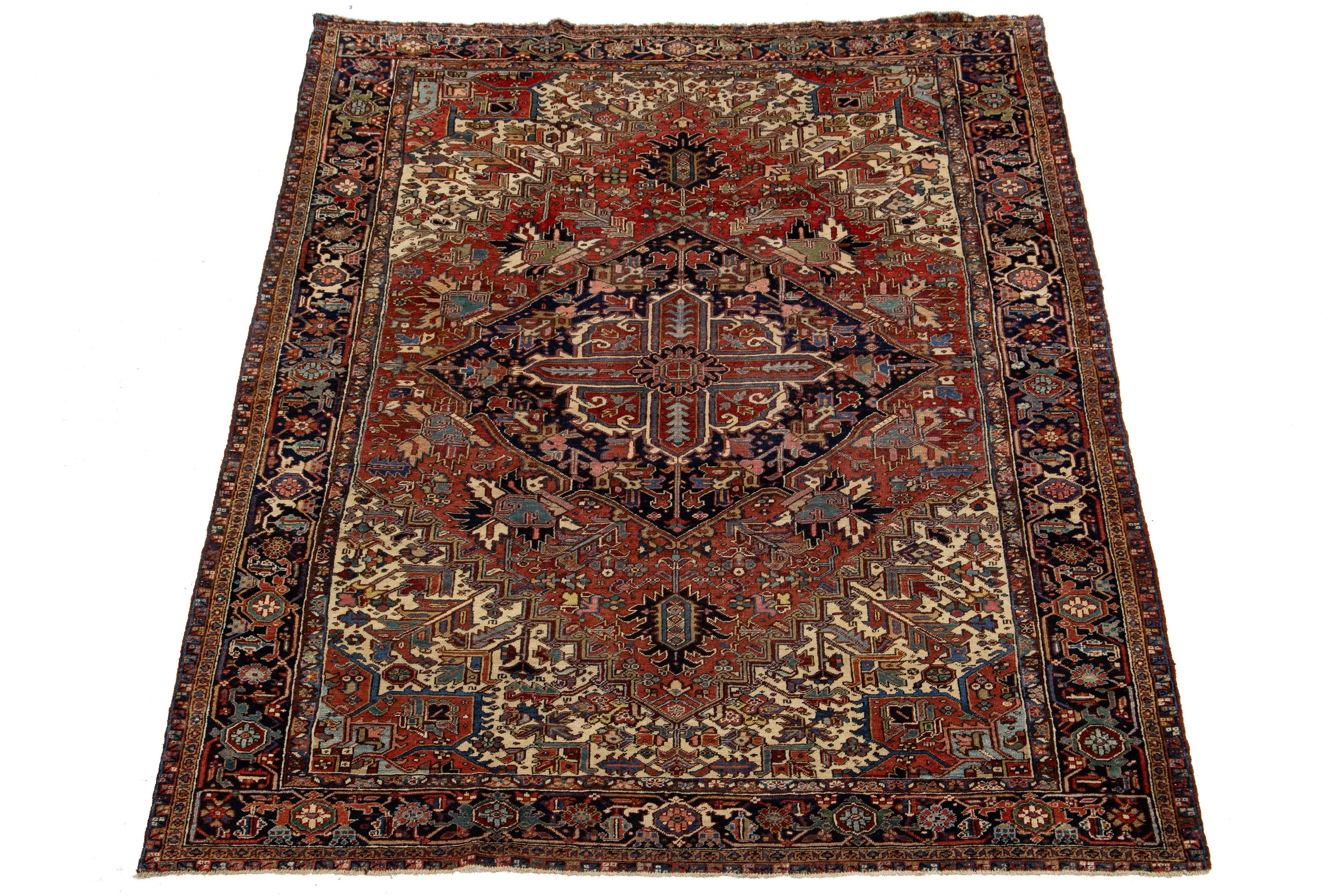 Discover the beauty of this antique Persian Heriz wool rug, showcasing a stunning multicolor allover pattern that brings life to a luxurious deep red background.

This rug measures 9'3'' x 12'.

