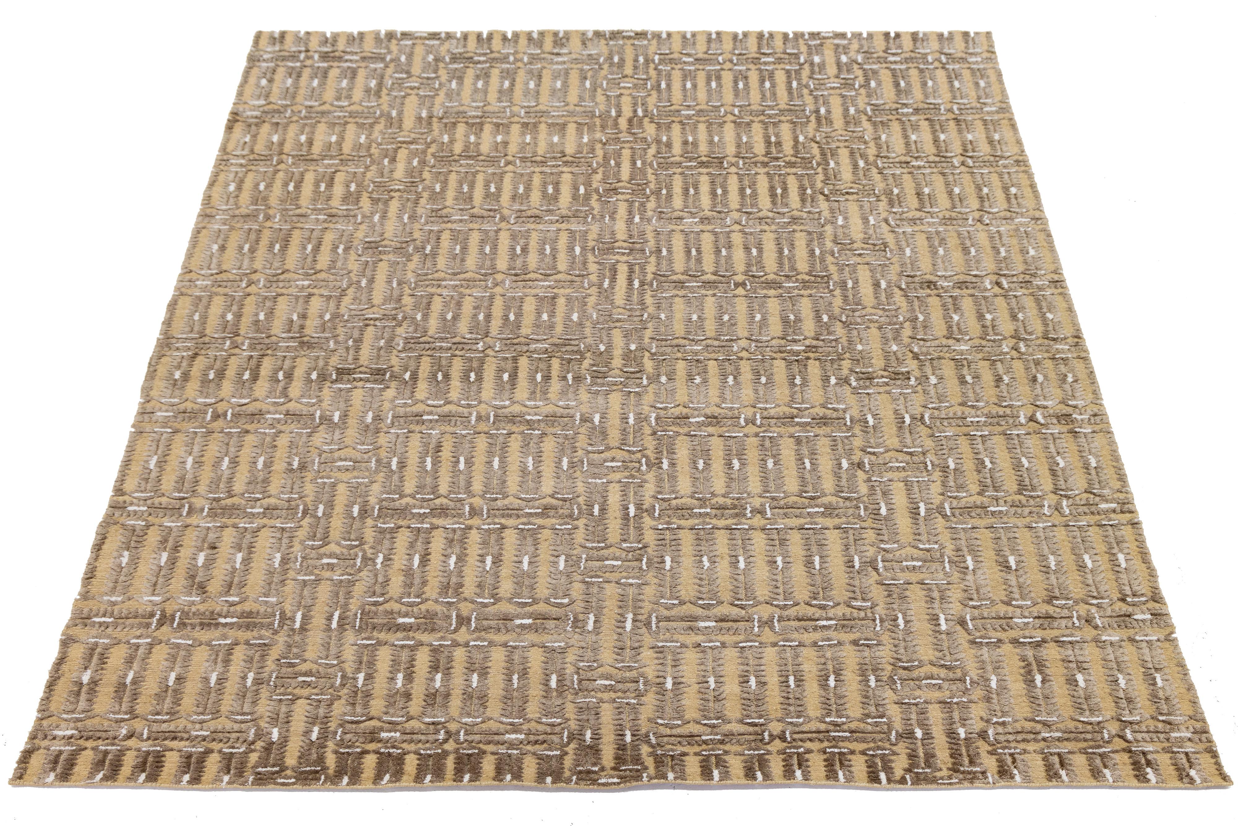 This beautiful modern Soumak hand-knotted wool rug has a tan field. It features beige accents in a gorgeous all-over geometric design.

Contents:60%WOOL,30%JUTE,10%COTTON

This rug measures 9' x 11'8