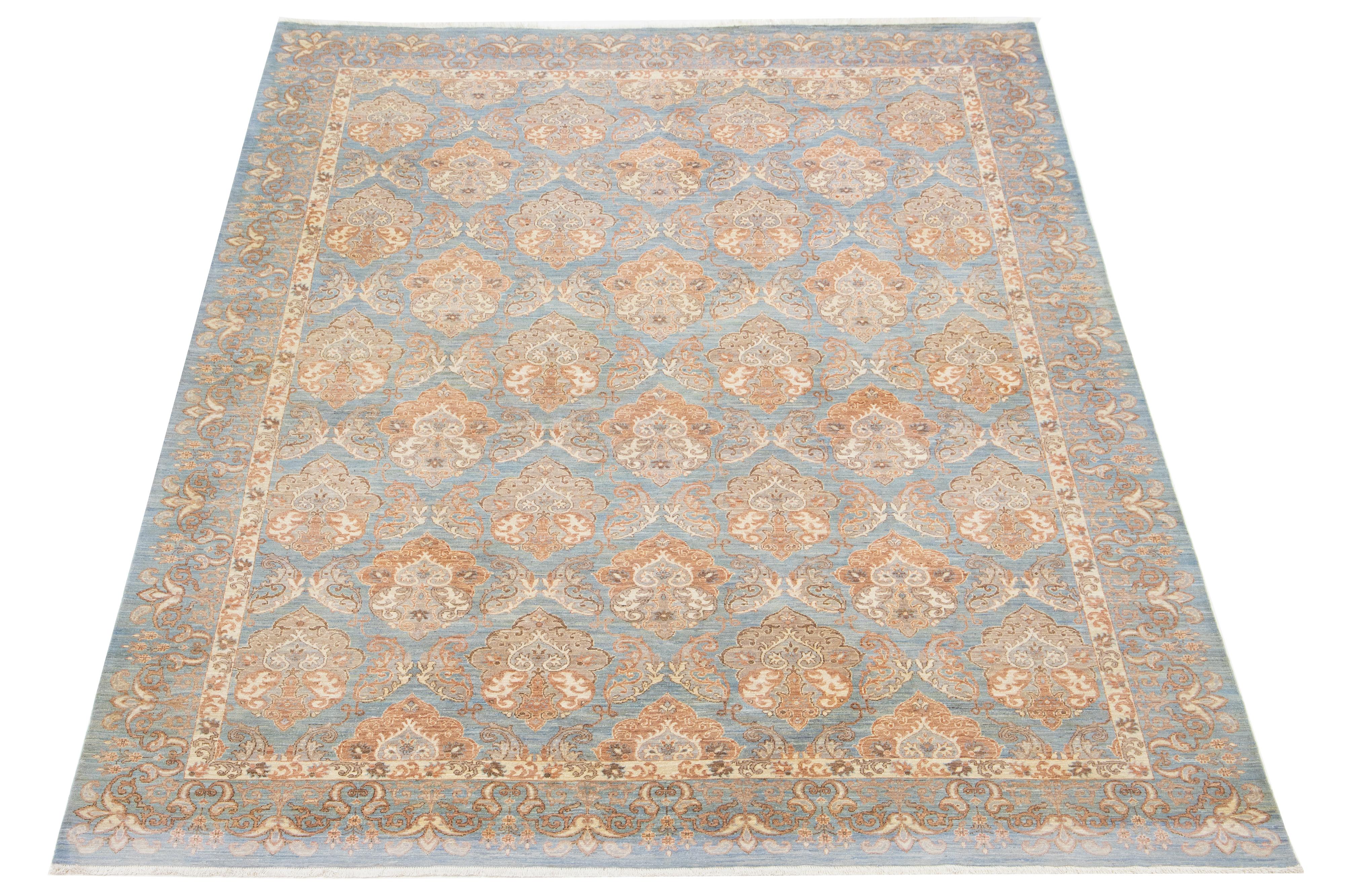 This contemporary Oushak-style wool rug showcases the exquisite craftsmanship of traditional Oushak design. It boasts a striking blue background decorated with an intricate floral pattern, displaying a refined blend of beige and copper tones that