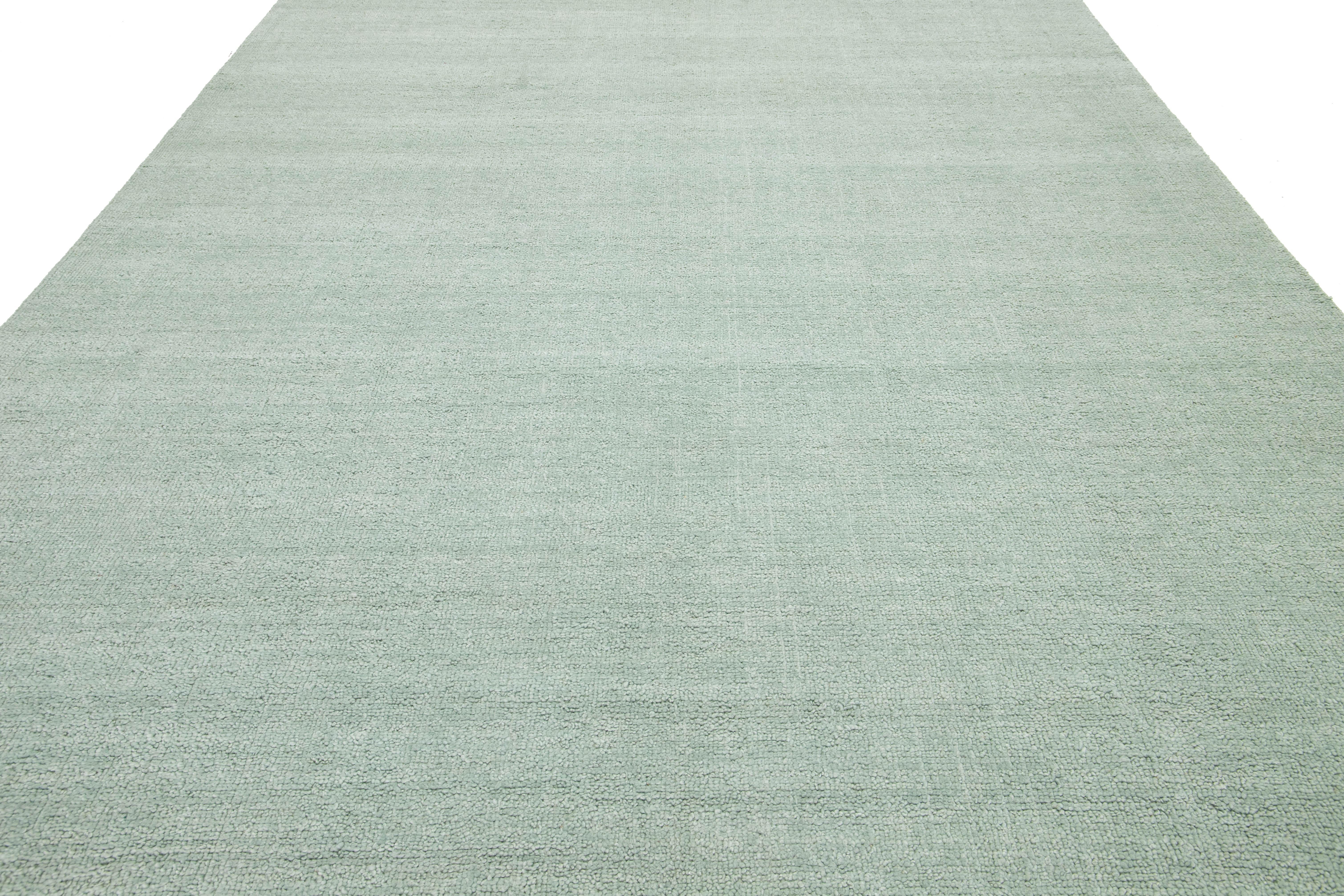 Abili artigiani realizzano con cura questo tappeto indiano contemporaneo in lana annodato a mano, dal design minimalista. Il suo morbido colore verde chiaro funge da base versatile, completando senza sforzo una gamma di stili di interni che vanno