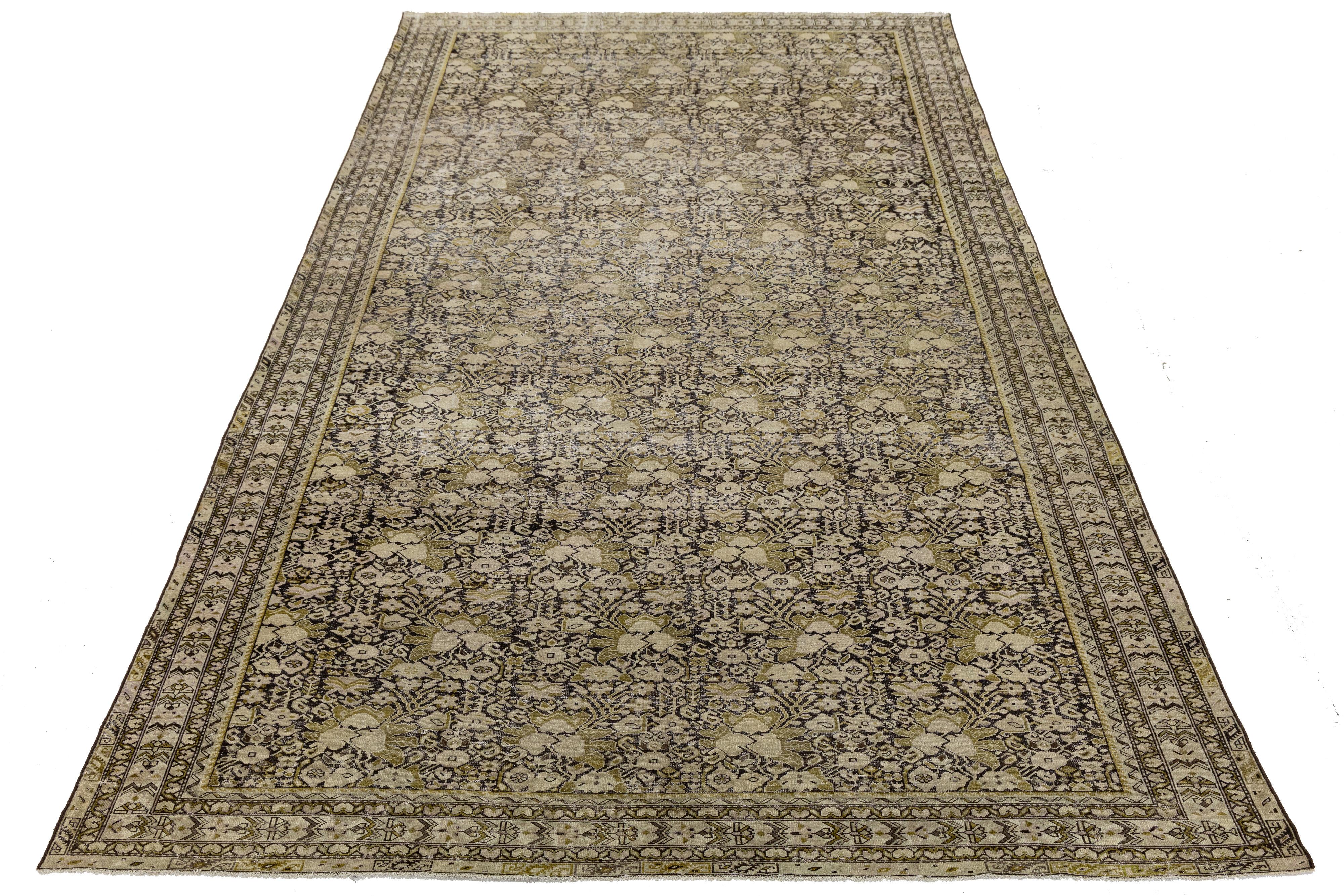 Questo elegante tappeto antico di Malayer, proveniente dalla Persia nord-occidentale, presenta un reticolo floreale e di viti finemente intrecciato nei toni tenui del beige, dell'oliva e del marrone. I suoi intricati bordi e l'equilibrata simmetria