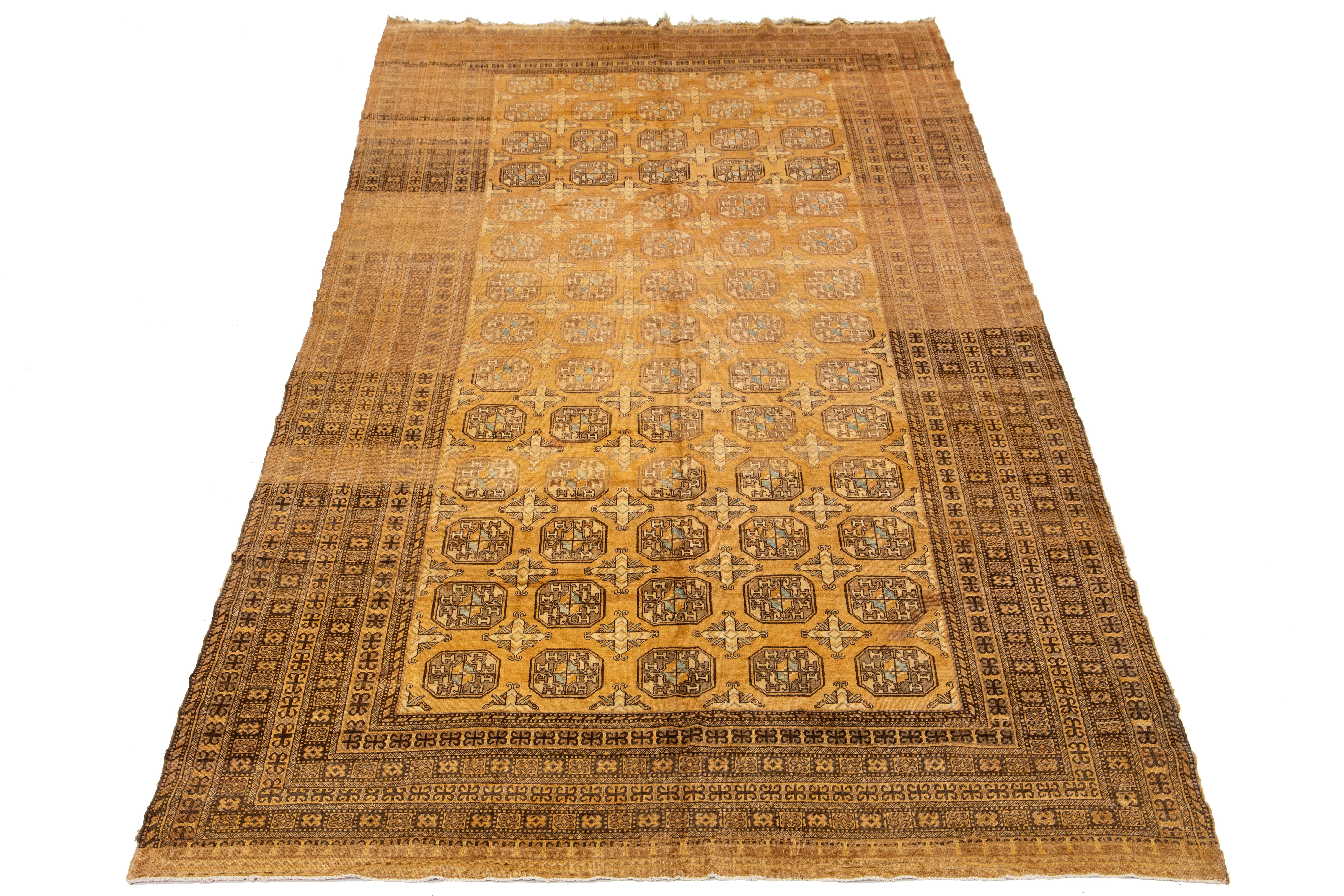 Superbe tapis ancien afghan en laine nouée à la main, avec un champ de couleur beige. Cette pièce présente des accents bruns, beiges et bleus dans un motif Gul.

Ce tapis mesure : 8'9