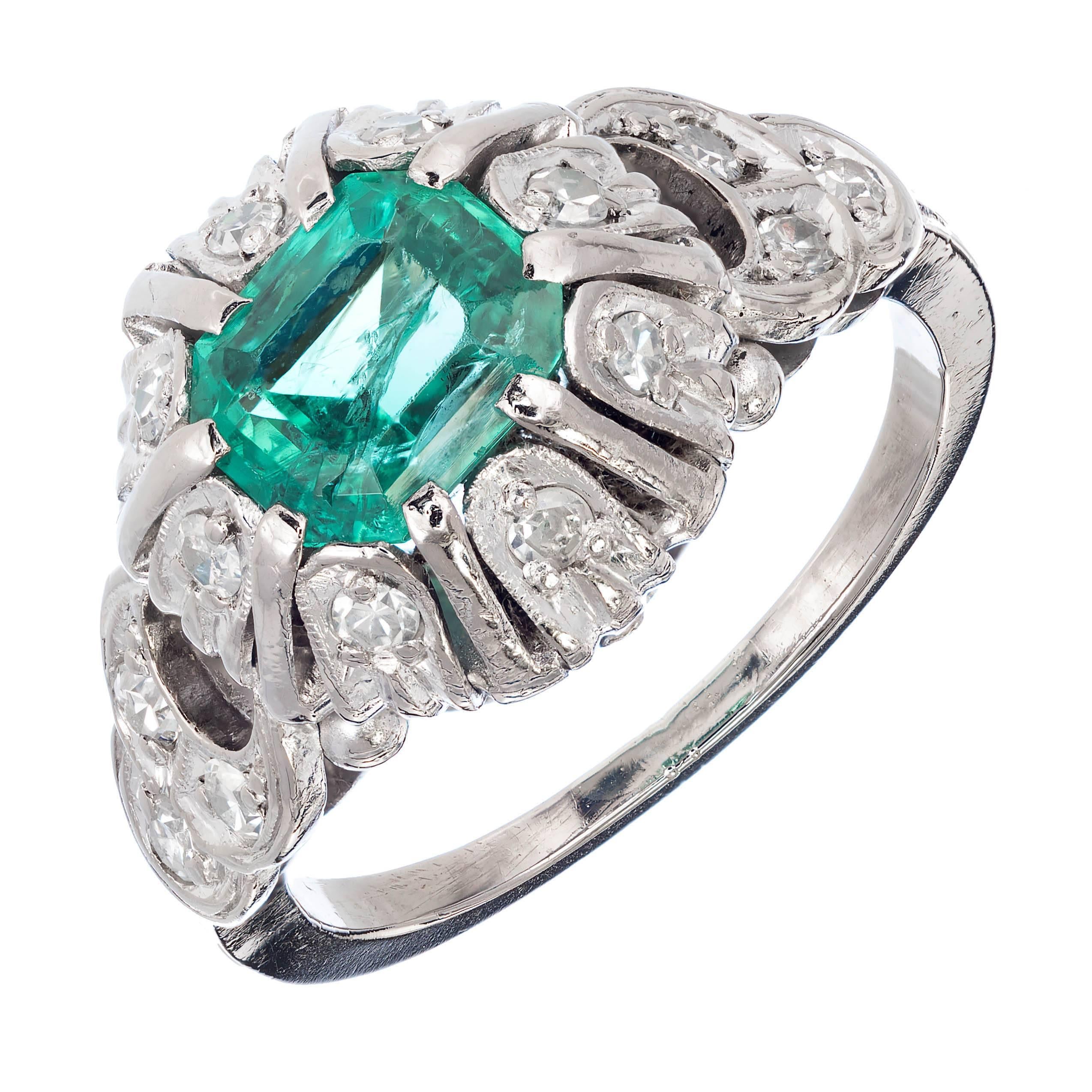 1900 Bright green Emerald and diamond engagement ring. Platinum setting with 14 round accent diamonds. AGL certified.

1 fine bright green Emerald AGL certified, approx. total weight .90ct, 6.35 x 5.60 x 3.96mm, natural color, faint to moderate