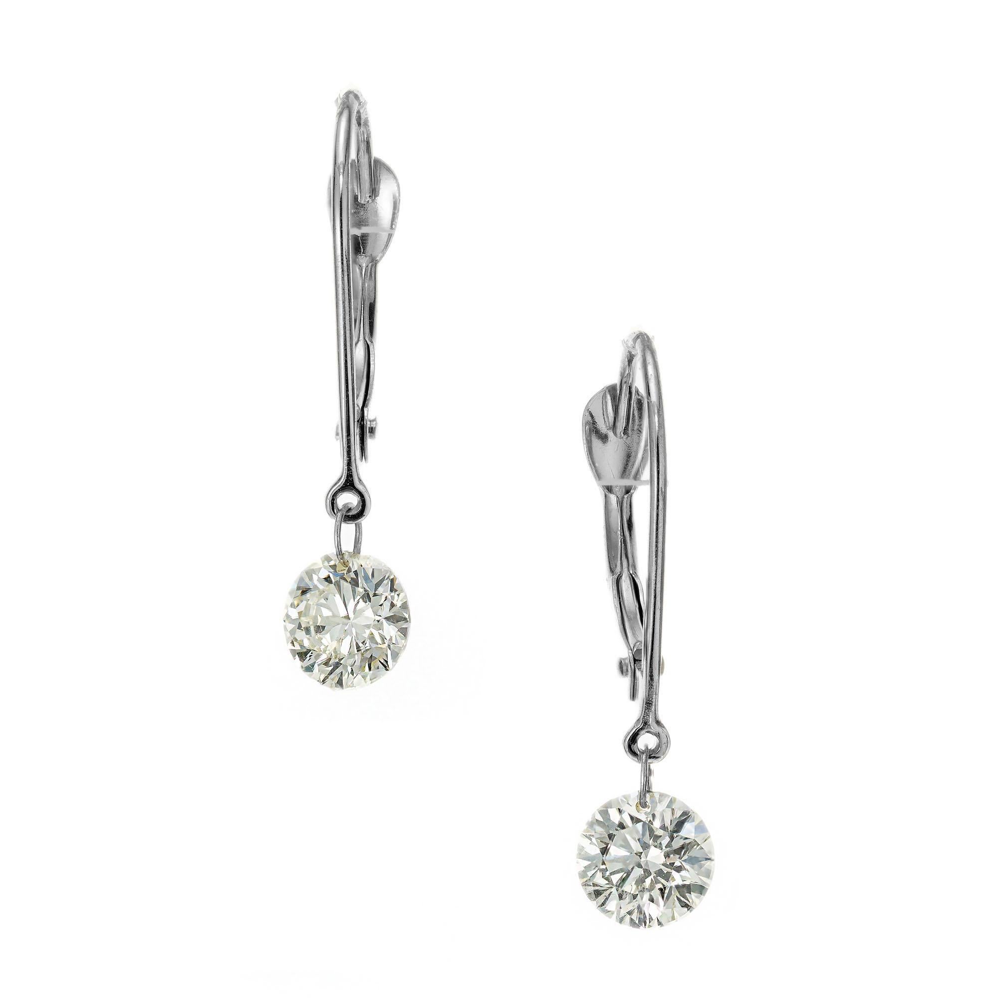 Diamond dangle earrings. 2 round brilliant cut diamonds. 14k white gold wire lever back tops.  

2 round brilliant cut diamonds, H-I VS approx. .90cts
14k white gold 
Stamped: 14k
.7 grams
Top to bottom: 20mm or 13/16 Inch
Width: 4.9mnm or 3/16