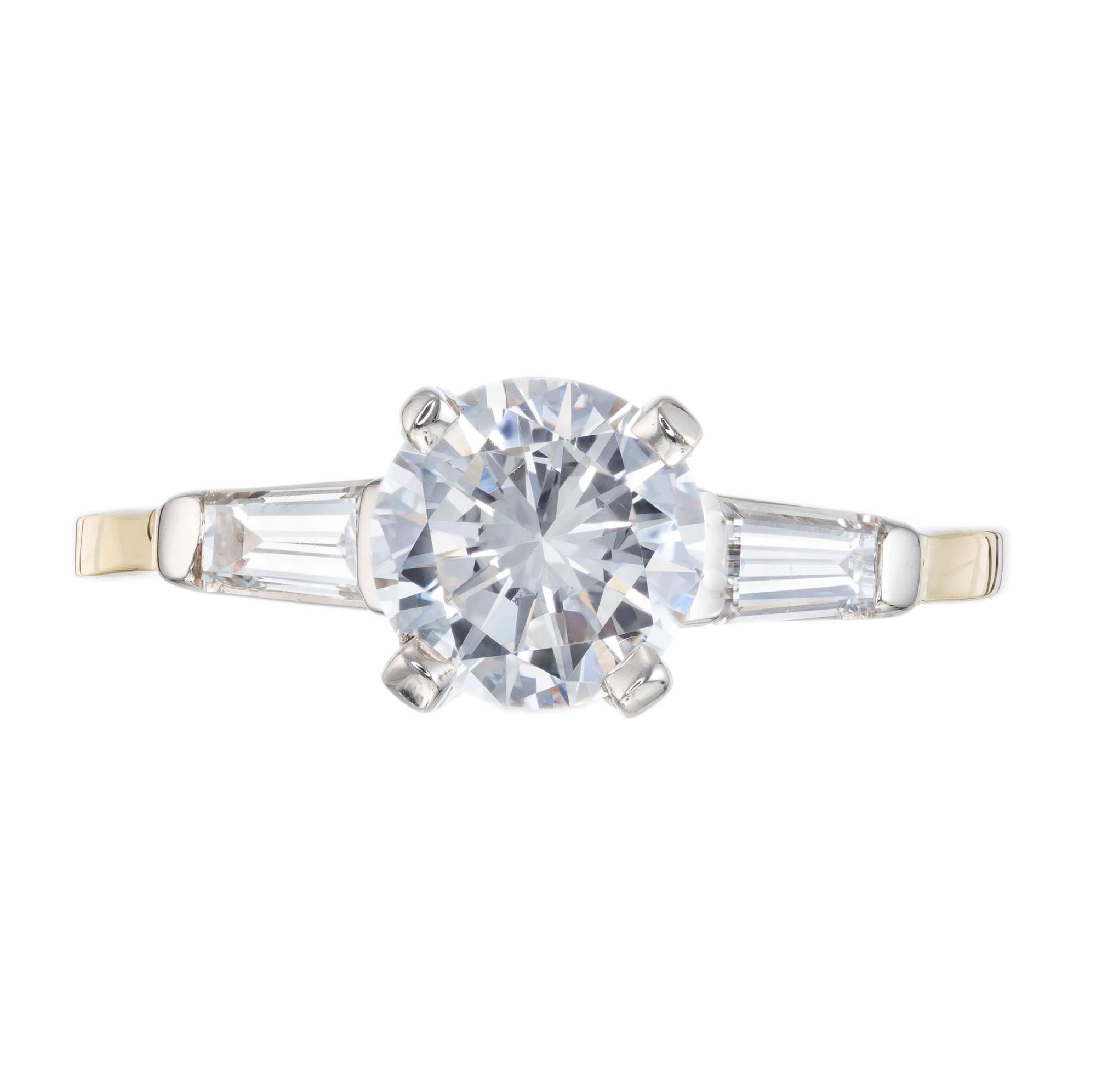 .90ct round center diamond in a three-stone engagement setting. 14k white and yellow gold with 2 tapered baguette side diamonds.  EGL certified. Circa 1940-1950.

1 round brilliant cut diamond, approx. total weight .90cts, F to G, VS2, 6.16 x 6.14 x
