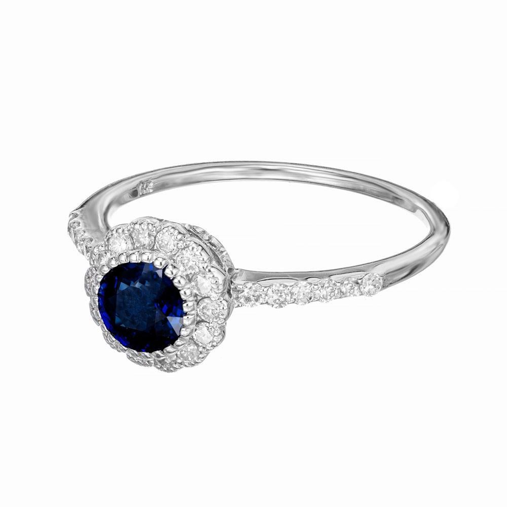 Royal blue Sapphire diamond engagement ring. Deep blue round cut .90ct sapphire center stone, mounted in a 14k white gold setting with a halo of round diamonds. Accented with diamonds long both shoulders of the shank. Simple an elegant. 

1 round