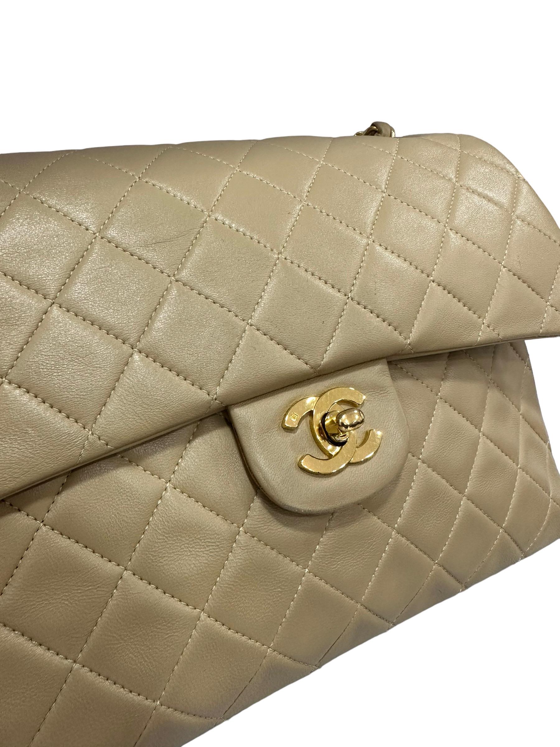 Chanel signed bag, vintage Flap model, made in beige quilted leather with golden hardware. Equipped with double flap, one internal with button closure, and one upper with CC logo turn lock closure. internally lined in beige smooth leather, quite