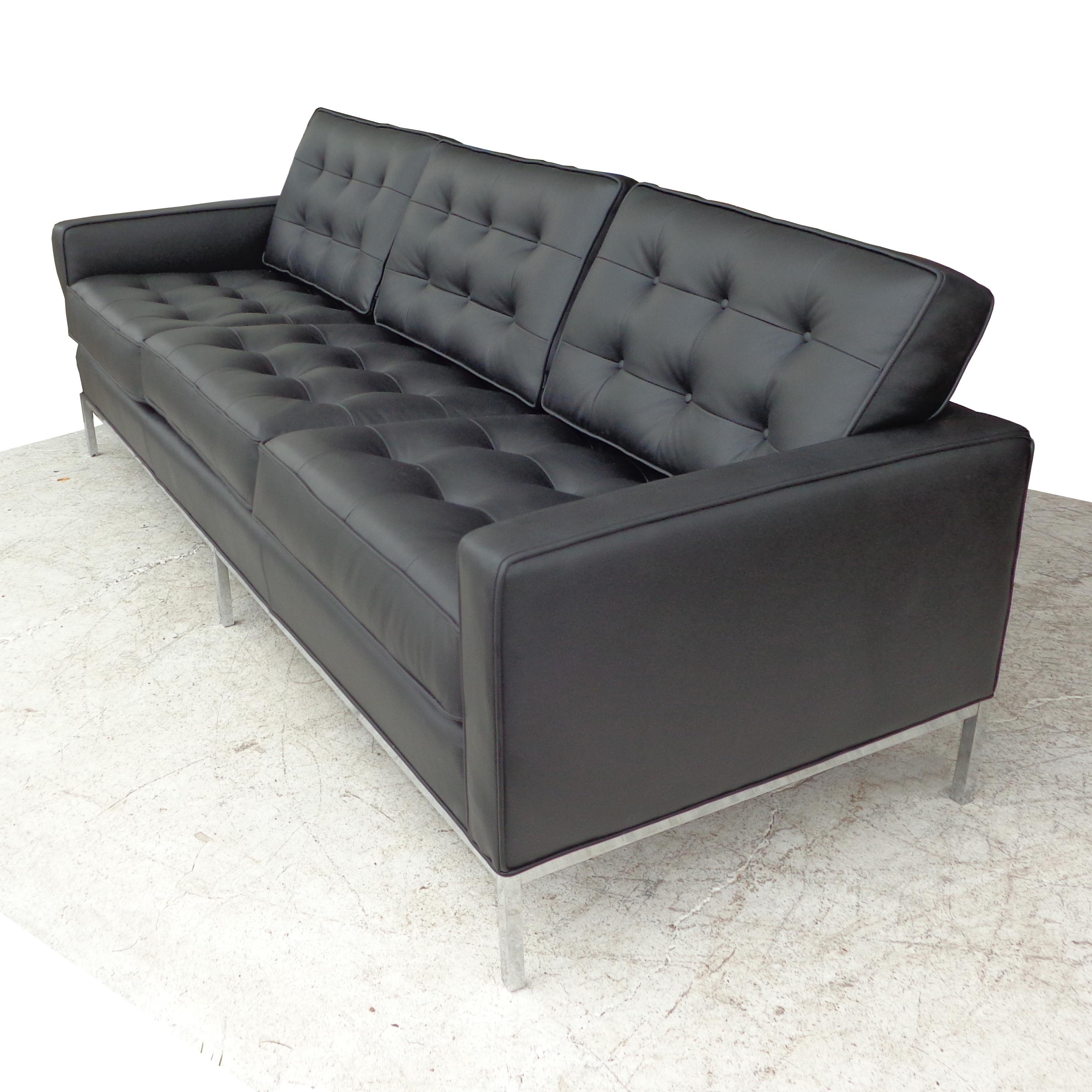 A midcentury Knoll classic designed by Florence Knoll. This three person sofa features tufted black leather upholstery with chrome plated steel legs. Measures: 90