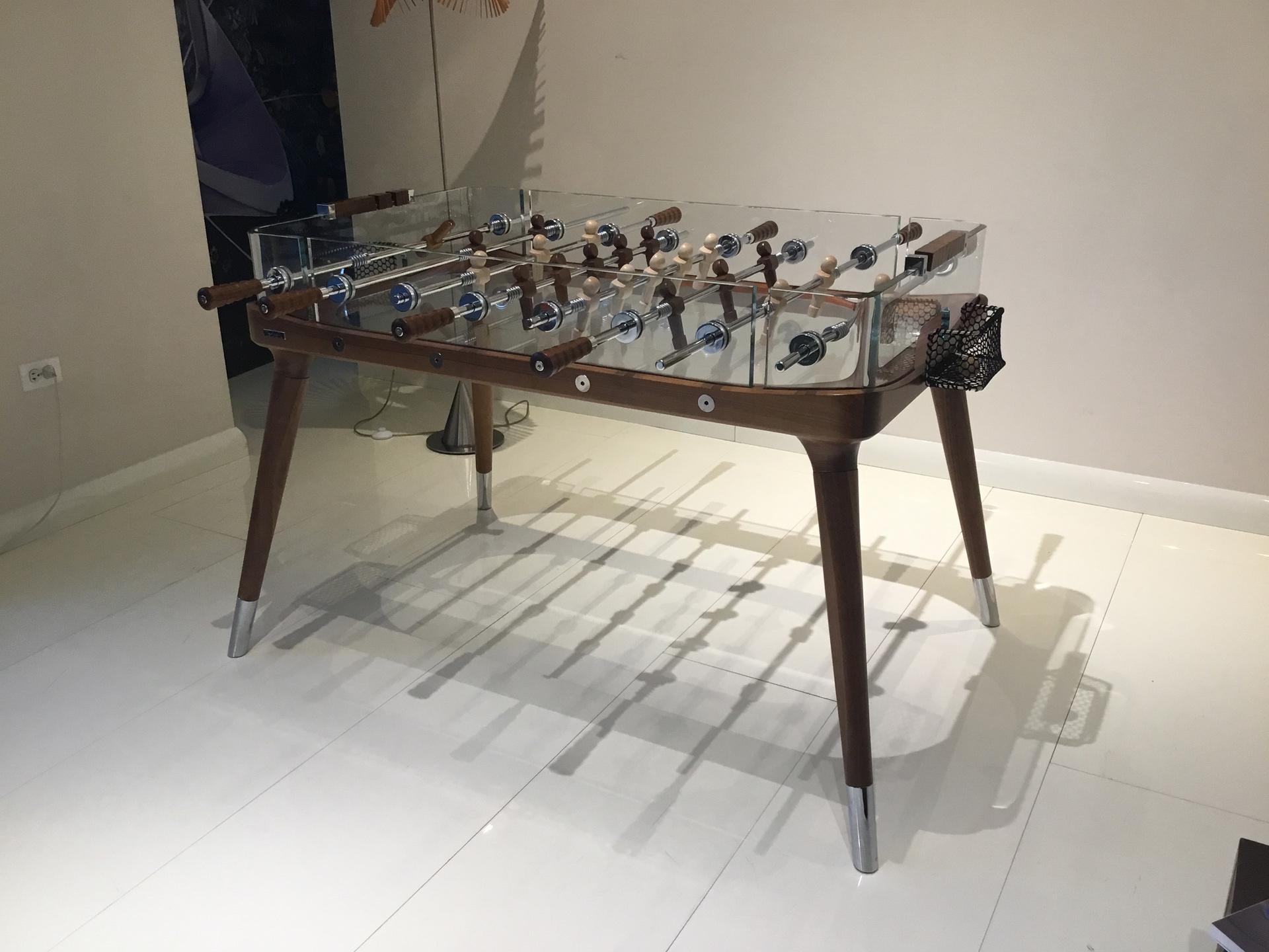 A surprisingly chic spin on the timeless game of foosball.

The attractively slender yet incredibly sturdy Canaletto wood legs and structure evoke the world of sailing while the luxurious, transparent crystal playing field redefines contemporary
