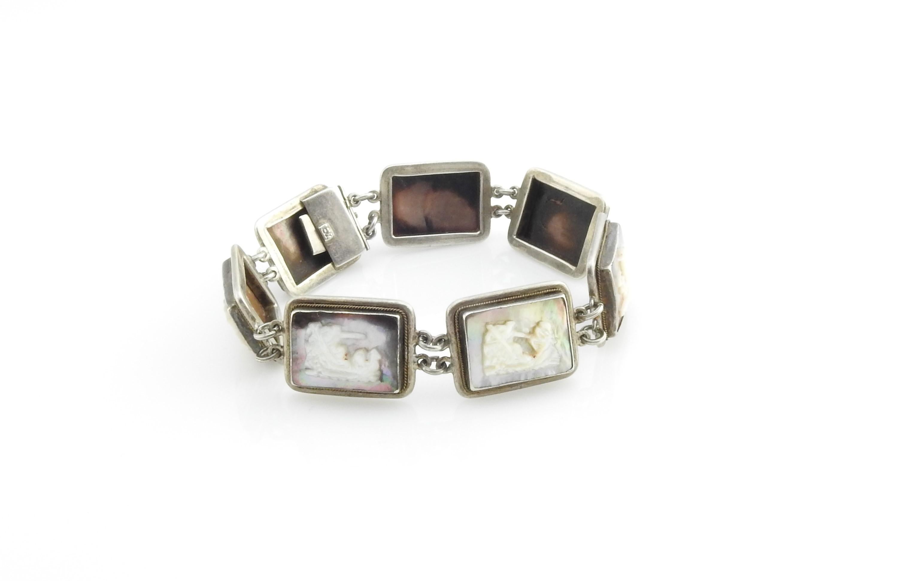 900 Sterling Silver Mother of Pearl and Abalone Bracelet-

Each link on this stunning sterling silver bracelet features a chariot motif in carved mother-of pearl and abalone shell.

Size:  7.5 inches

Weight: 23.0 dwt. / 35.8  gr. 

Tested for 900
