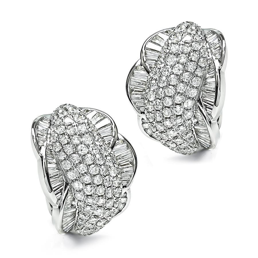 This is an elegant pair of 14k white gold earrings. The earrings feature sparkling round and baguette cut diamonds that weigh approximately 9.00ct. The color of these diamonds is G with VS clarity. The earrings measure 26.5mm by 22mm and weigh 19.3