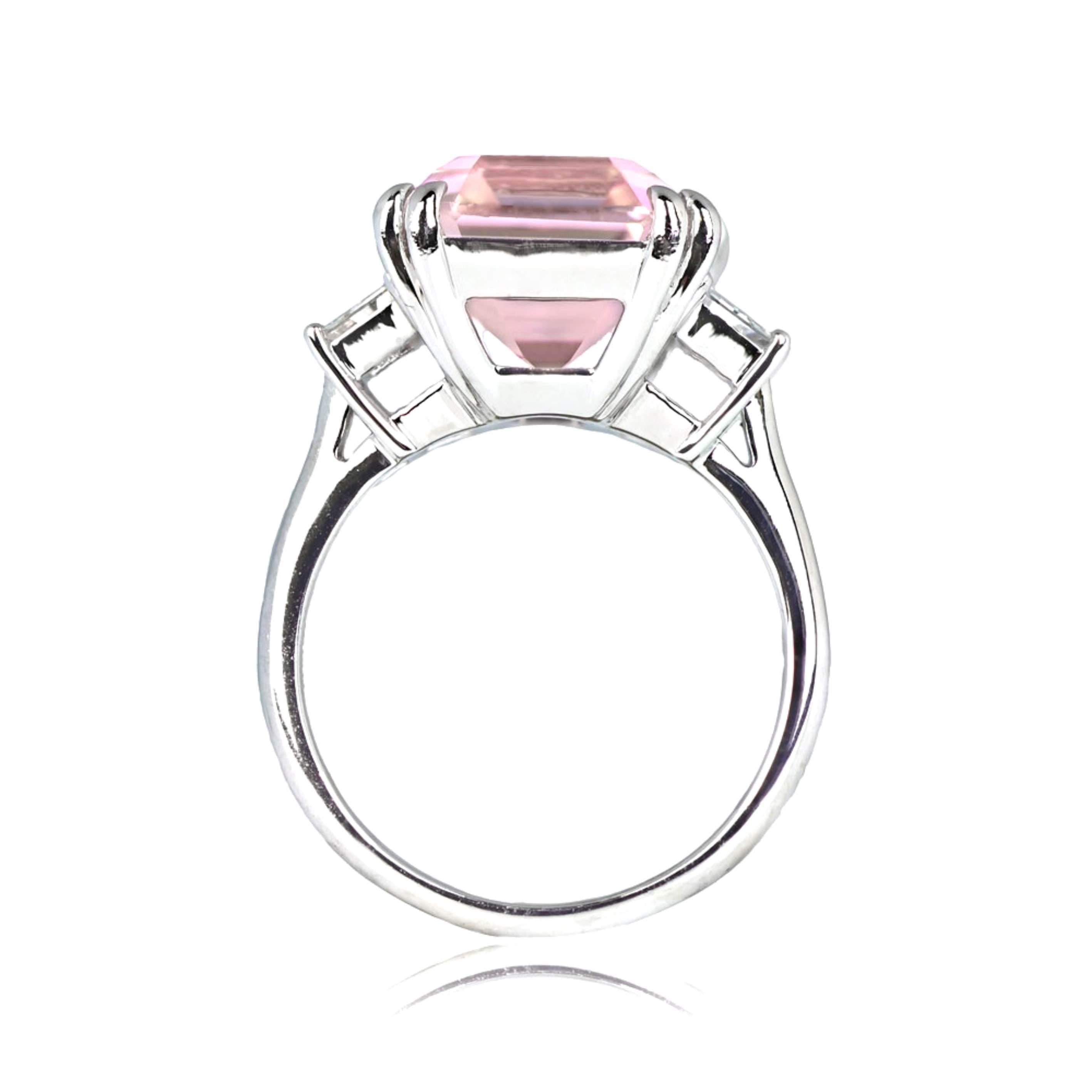 A stunning gemstone and platinum ring showcases a prong-set, breathtaking 9.00-carat natural kunzite with a vivid pink hue and remarkable clarity. The center stone is flanked by a pair of bezel-set trapezoid cut diamonds on the shoulders, boasting a