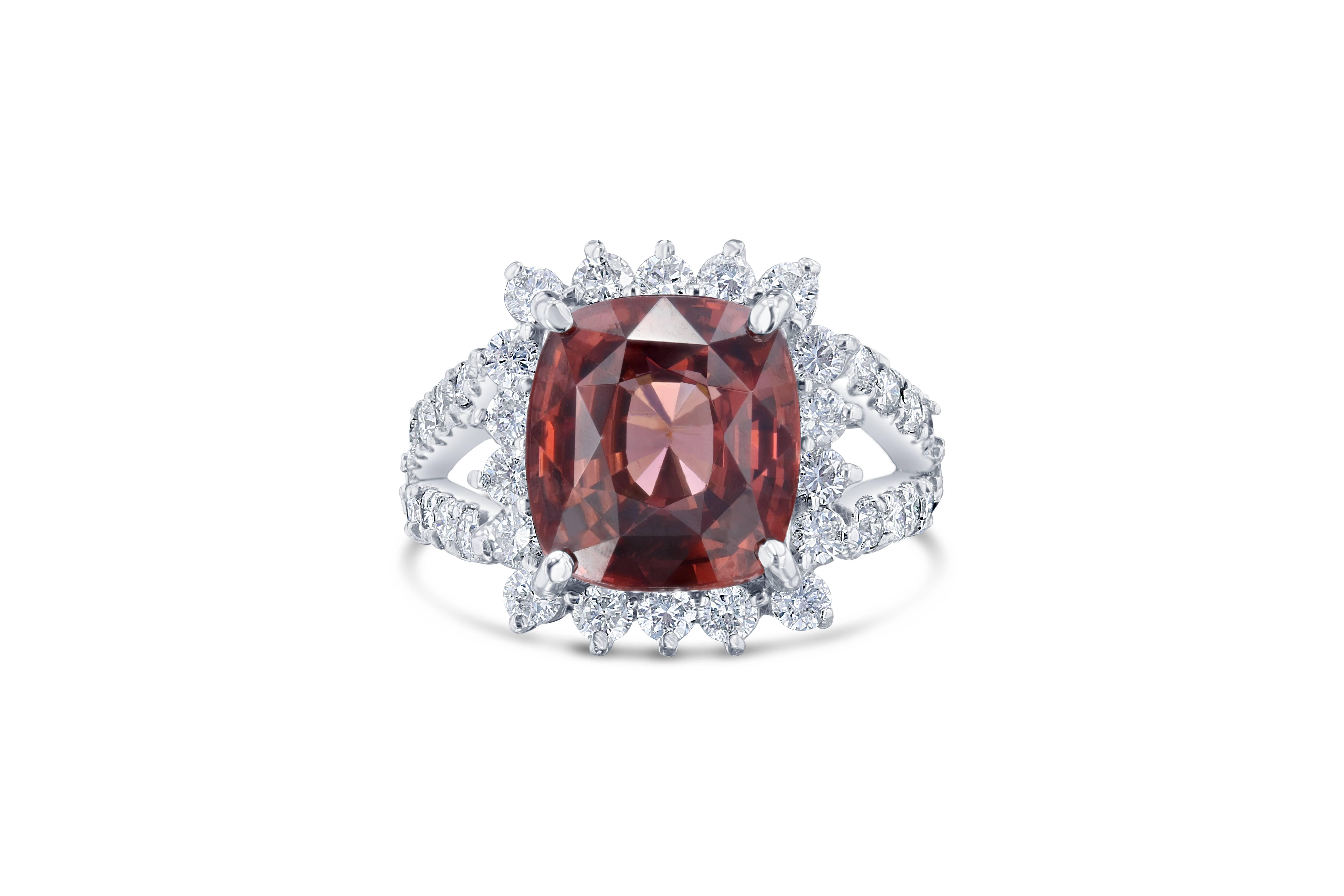 This beautiful ring has a 7.75 carat Spessartine set in the center of the ring. A Spessartine is a natural stone that is actually a part of the Garnet family of stones. The ring is surrounded by 36 Round Brilliant Cut Diamonds that weigh 1.26 carats