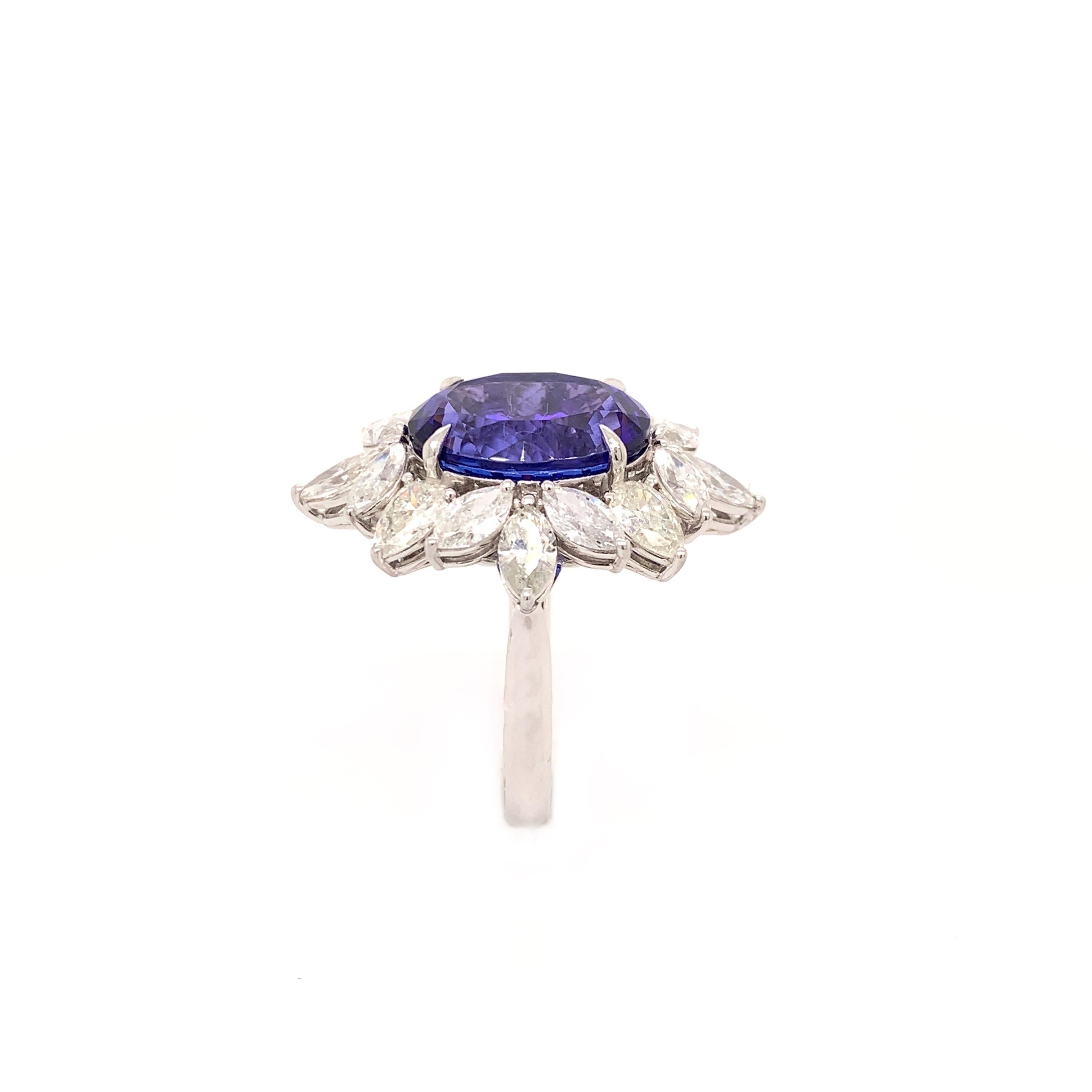 Glamorous tanzanite cocktail ring. Intense violet-blue with purple tint, high brilliance, oval faceted natural 9.01 carats tanzanite encased in petal open mount, set in high profile, with four knife prongs, accented with pear brilliant cut diamonds.