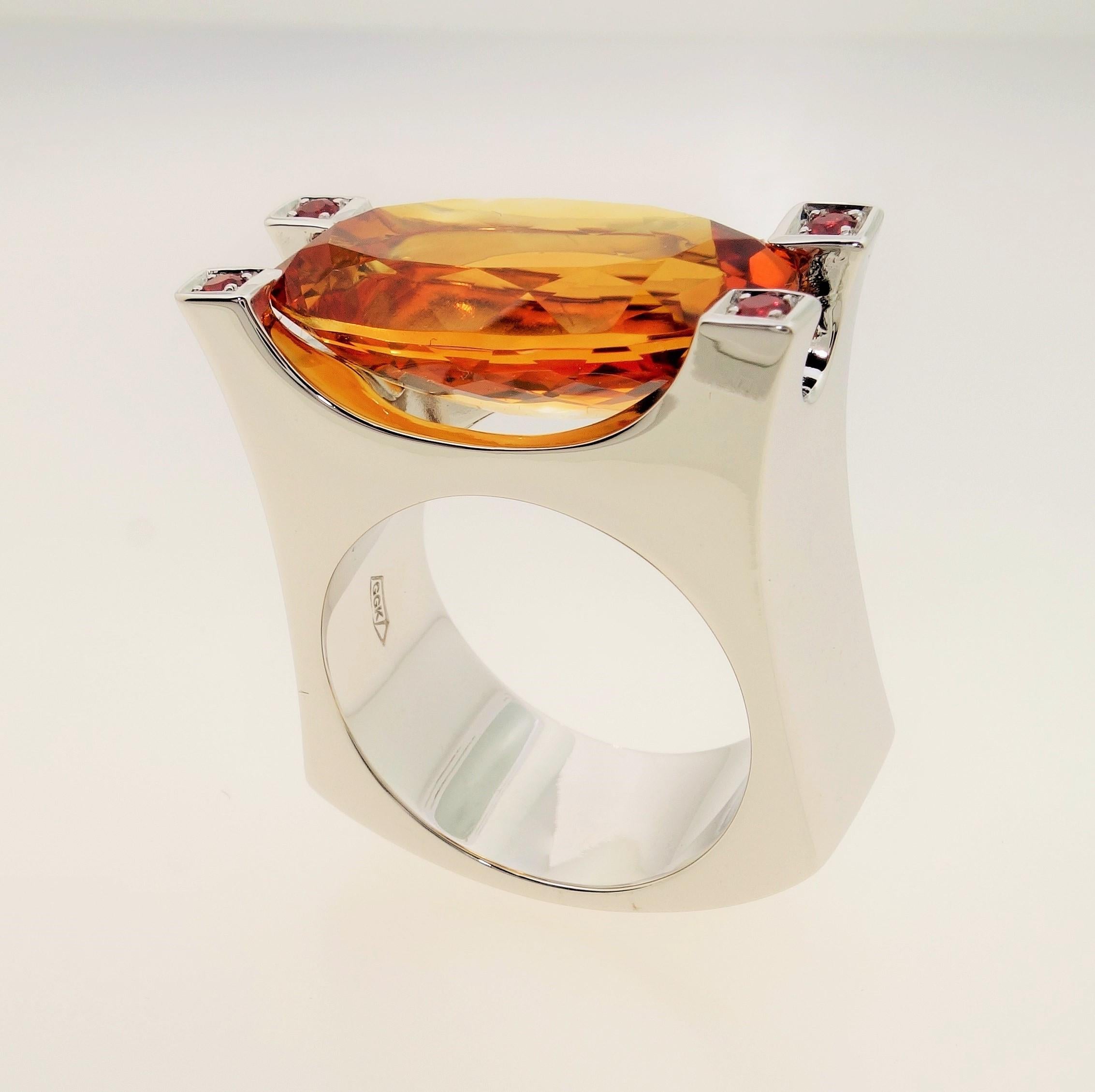 Stunning solitaire ring featuring a 9.03 Carat oval facet-cut Citrine measuring approx. 20mm x 10mm; each corner enhanced with a Diamond-cut round Sapphire; 4 Sapphires approx. 0.12tctw; Sterling Silver Tarnish-resistant Rhodium Satin finish