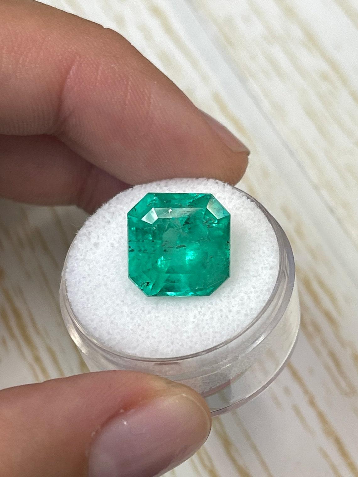 Stone: Emerald
Weight: 9.03-carats
Shape: Asscher Cut
Clarity: Transparent
Luster: Very Good
Color: Deep Bluish Green
Measurements: 12.52mm x 12.47mm x 9.33mm
Geographic Origin: Colombia
Treatment: Natural, Oiling

Comments: Due to their growth