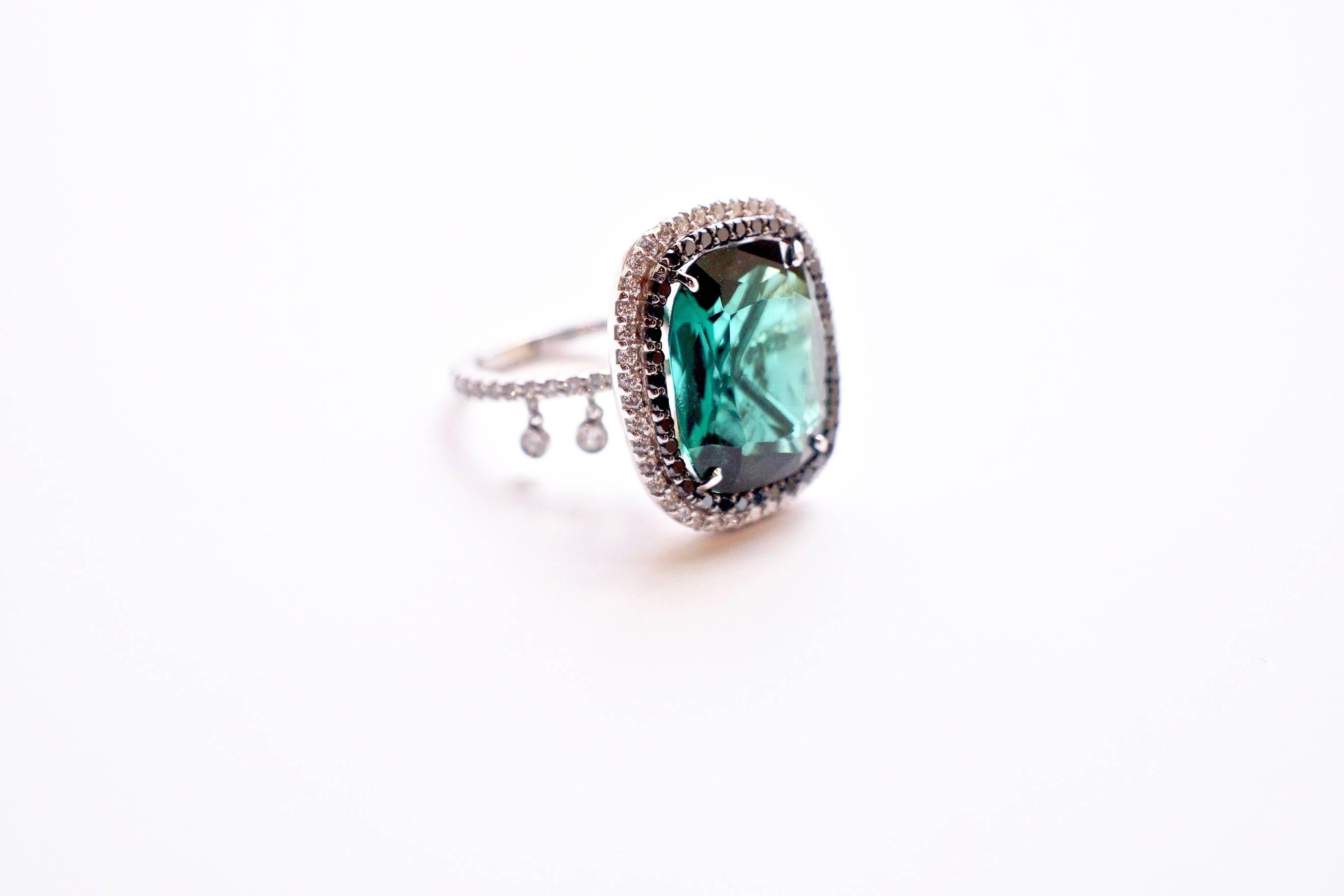 Green Tourmaline Shimmee® Ring
An eighteen-karat white gold ring, showcasing a 9.06 carat cushion-shaped faceted green tourmaline outlined first in black diamonds, followed by an outline of white diamonds.  For a touch of whimsy and modest movement,