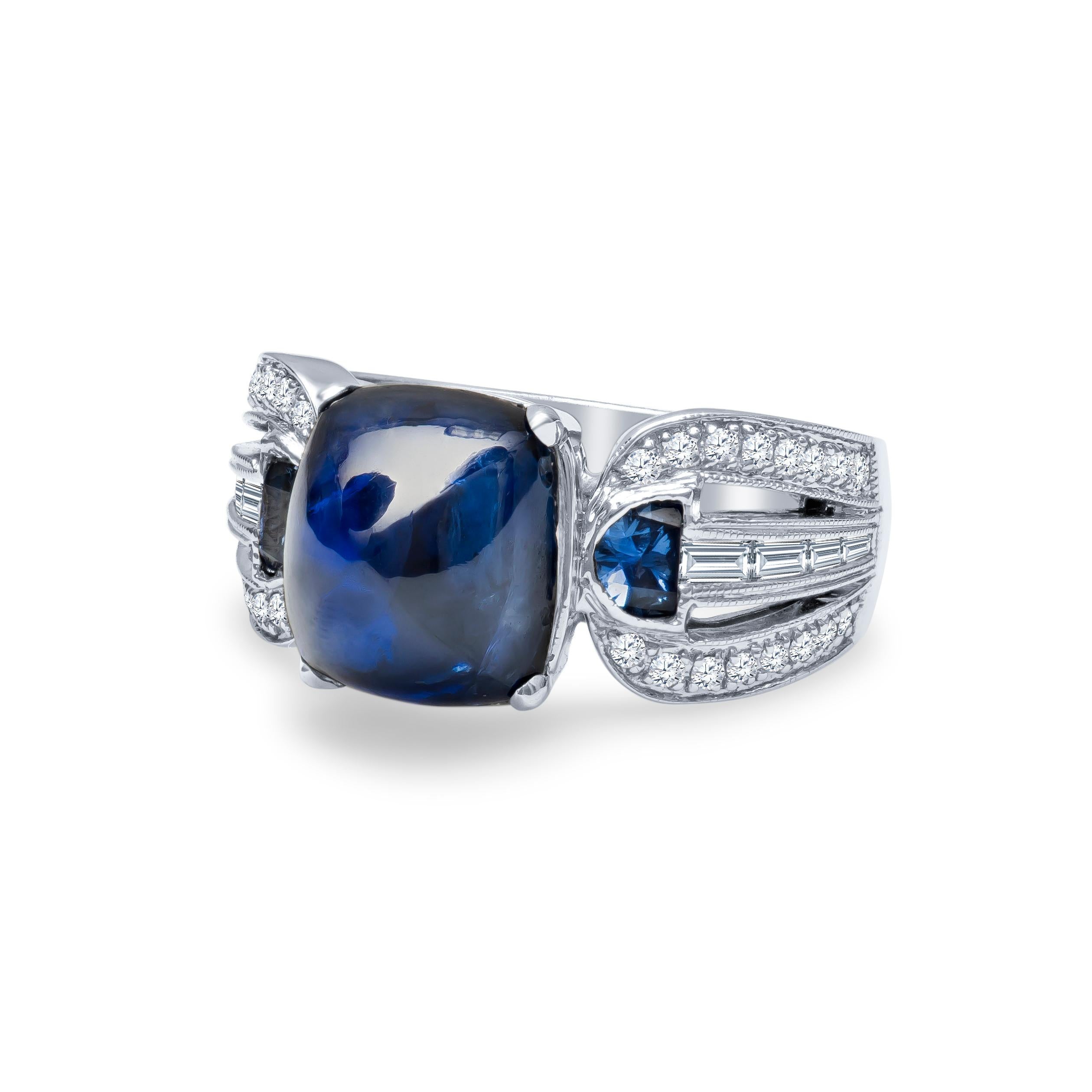Stunning 9.06 carat sugarloaf cabochon natural blue sapphire with 0.42 carats total of half moon blue sapphires and 0.57 carats total in baguette and round brilliant diamonds. Set in 18K white gold, size 6.5. This ring may be resized larger or